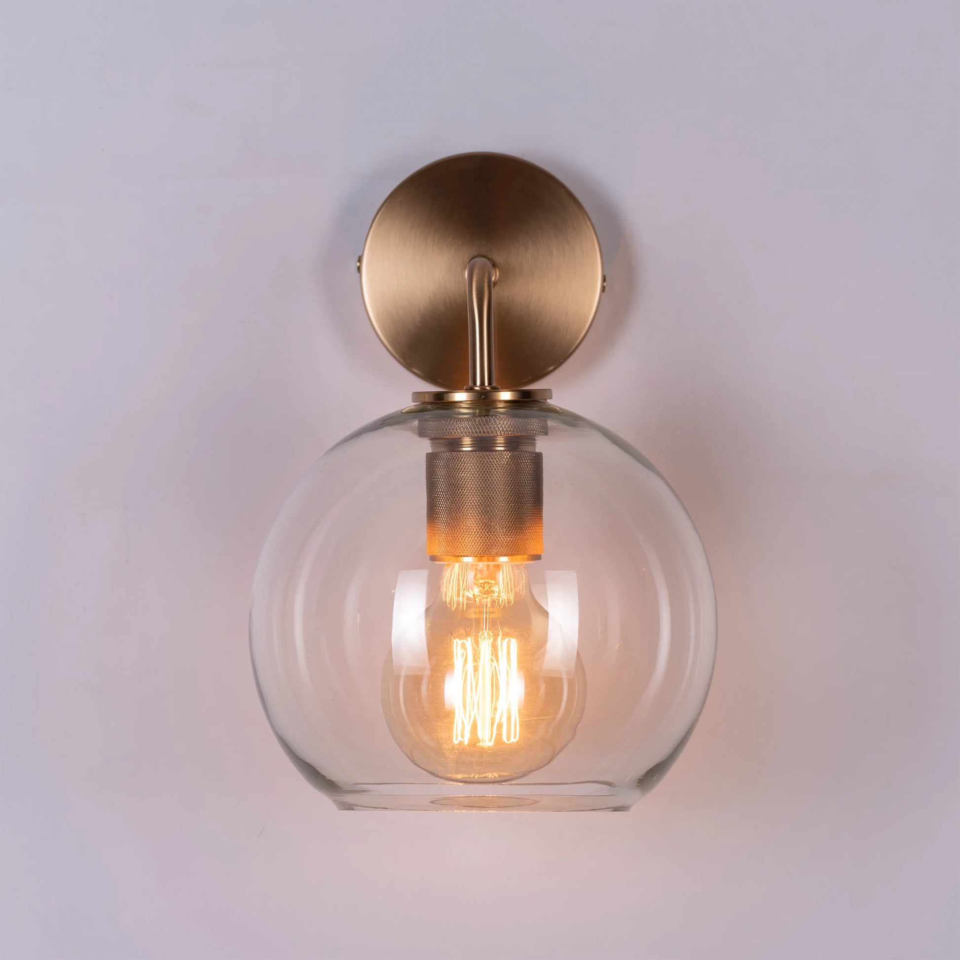 Endgame Clear Glass Wall Light - Minimalist and refined wall lighting fixture featuring a clear glass cylinder that houses the integrated LED light source, accentuated by a sleek metal housing.