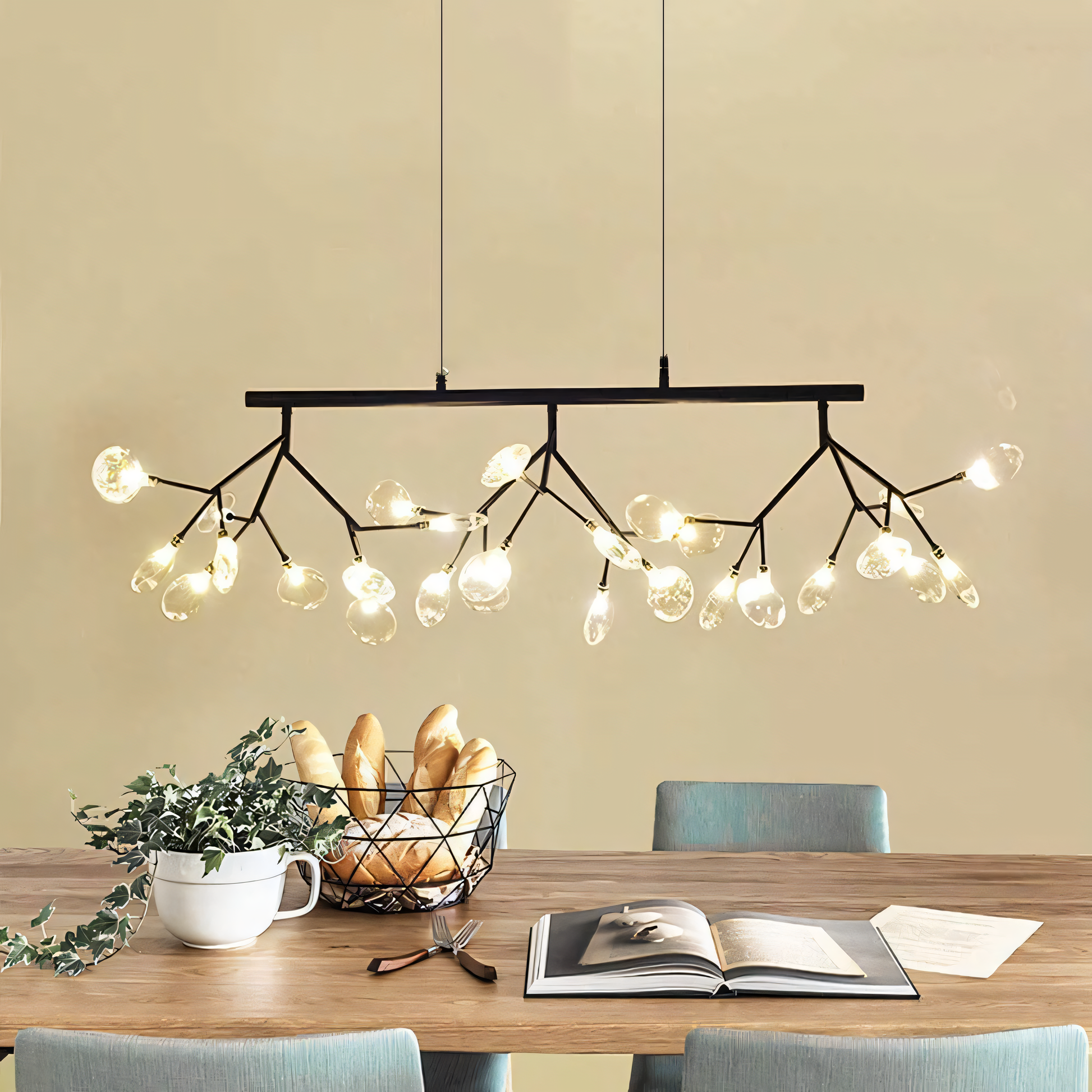 The Blaze Modern Dining Chandelier, a forest-inspired centerpiece, hangs above a dining table in a modern home. The chandelier's warm light fills the room.