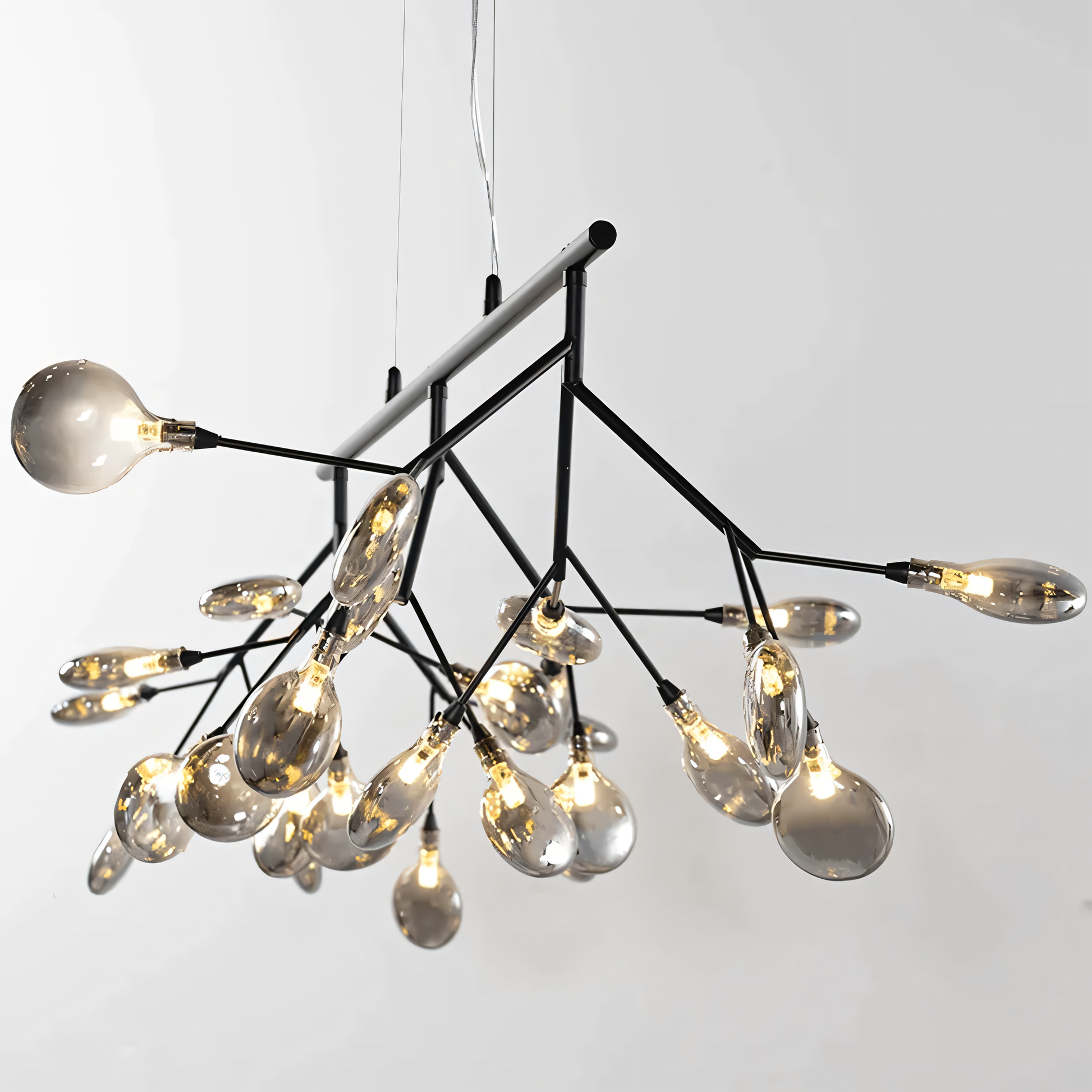 A black, circular chandelier with rods tipped with LED bulbs hangs from a dining room ceiling. The chandelier casts a warm, inviting glow on the space.