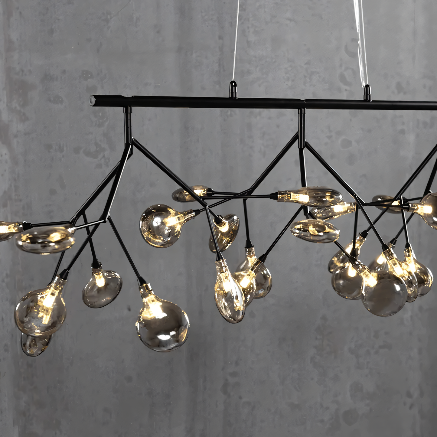 The Blaze Modern Dining Chandelier, a forest-inspired centerpiece, hangs above a dining table in a modern home. The chandelier's warm light fills the room.