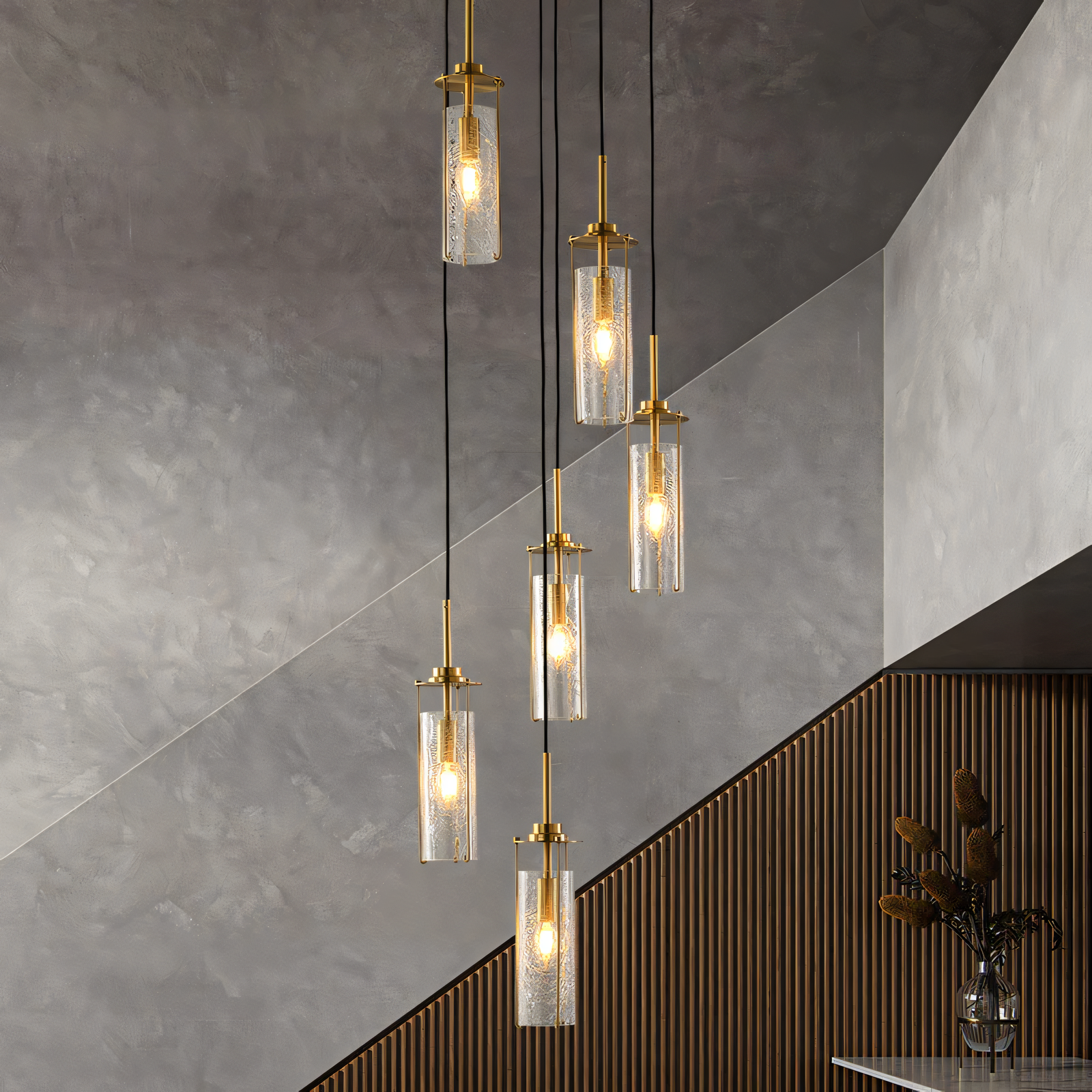 The 6 Light Brass Gold Crackle Glass Double Height Stair Chandelier, a coastal-inspired masterpiece, hangs majestically in the stairwell of a modern beach villa. The chandelier's warm light fills the space.