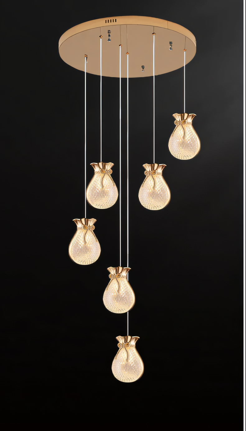 Elegant brass and crystal 6-light LED chandelier cascading down a tall staircase in a modern, luxury home interior
