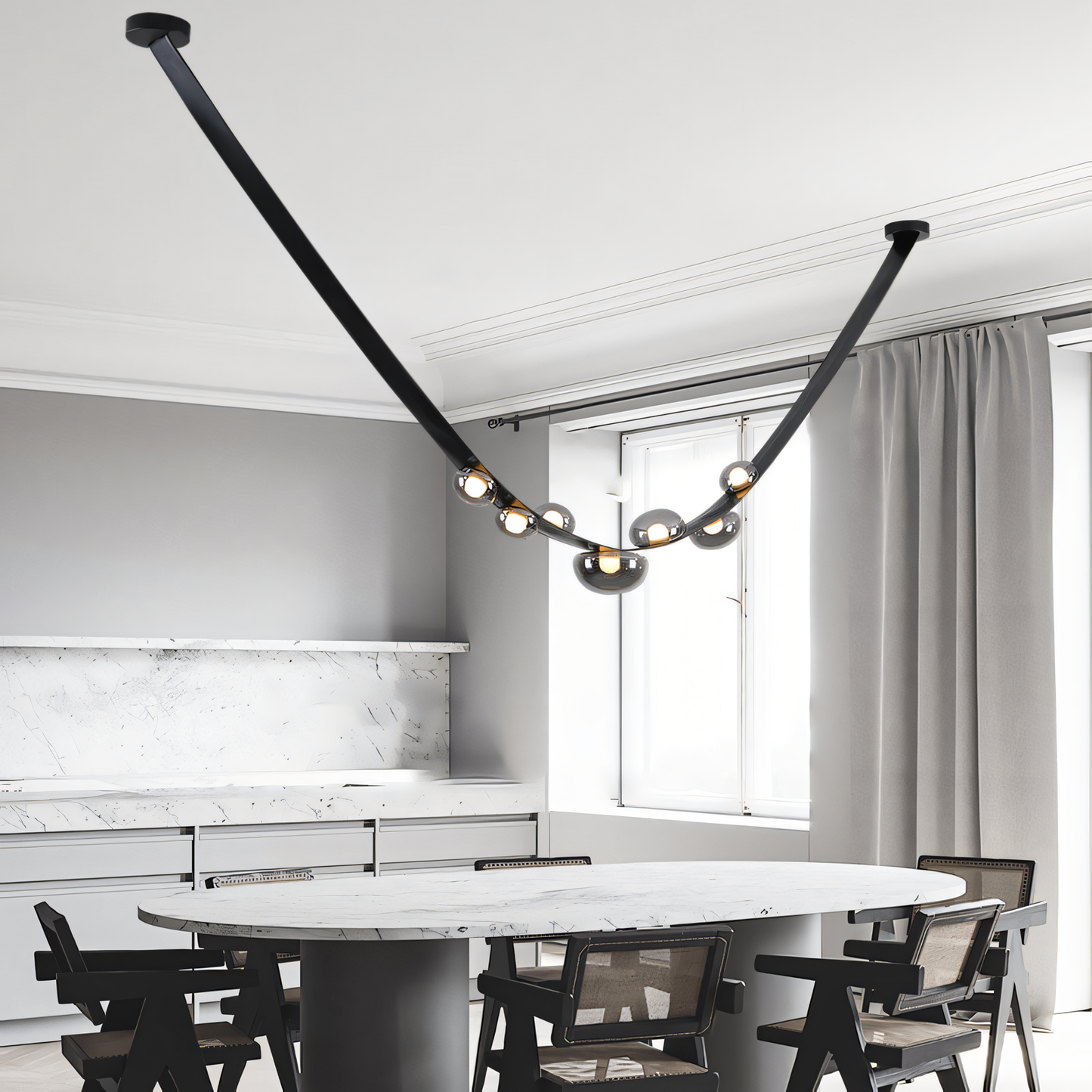 A black leather belt wraps around the central frame of this modern chandelier, suspending smoky glass globes that cast a warm glow on a dining table.