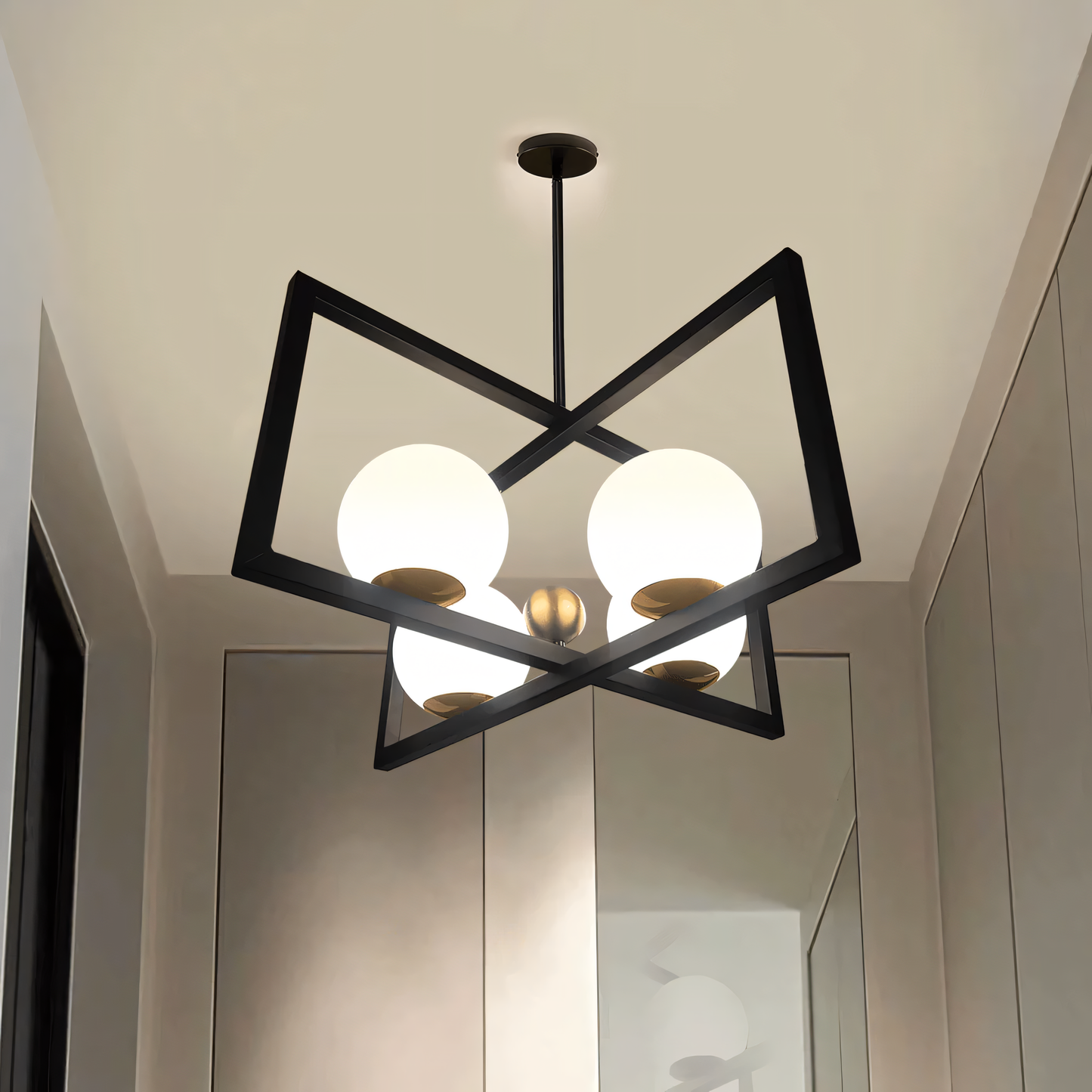 A rectangular bronze hanging light with clear glass globes hangs from a vintage living room ceiling. The light casts a warm, inviting glow on the space.