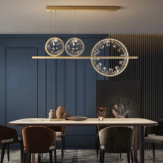 A round gold chandelier with a modern design hangs from a living room ceiling.