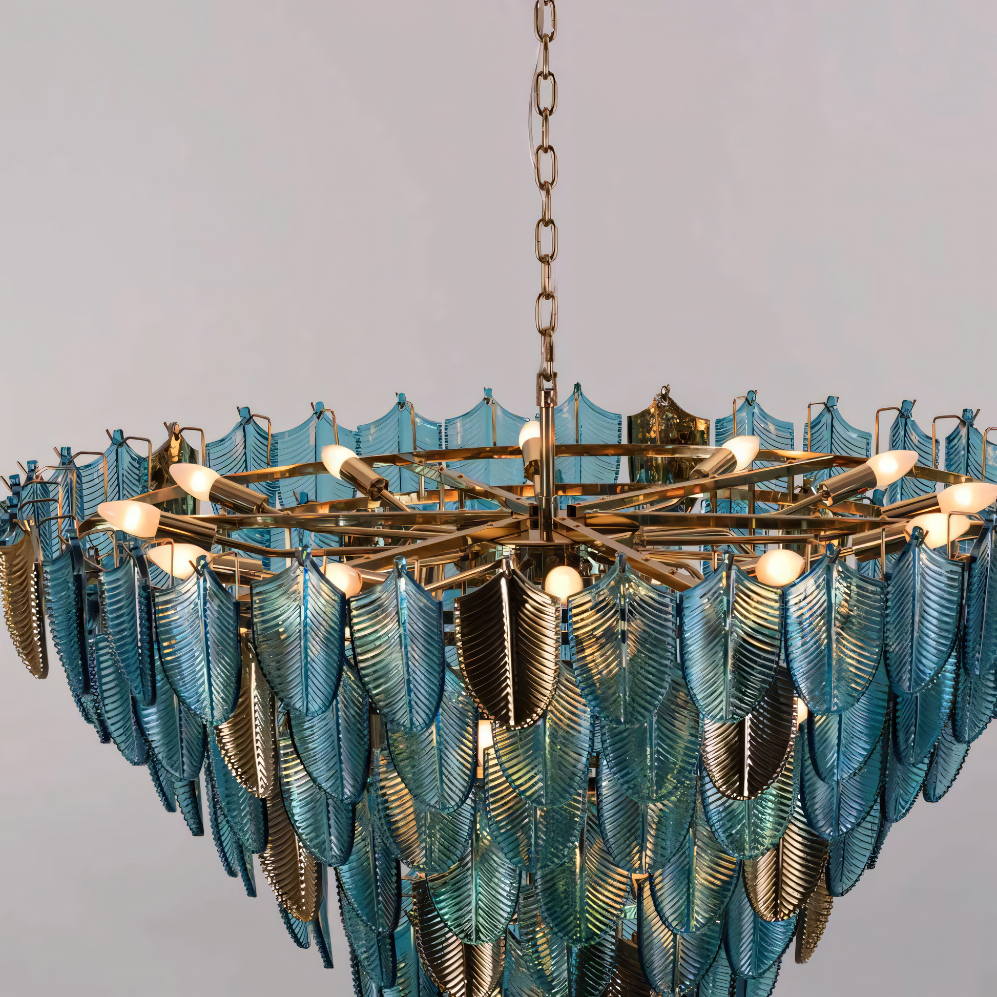 The Gratus Luxe Modern Glass Leaf Chandelier features a circular chrome frame with curved metal branches tipped with hand-blown glass leaves.