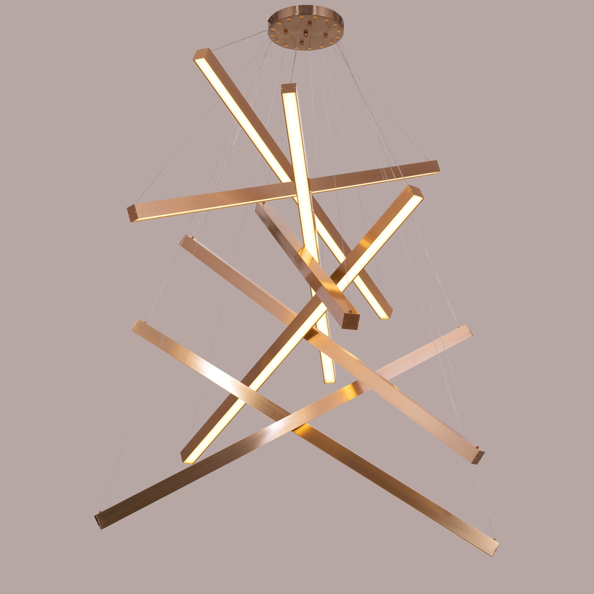 Large gold Toast To Tomorrow chandelier with double-height design illuminating a luxurious living room