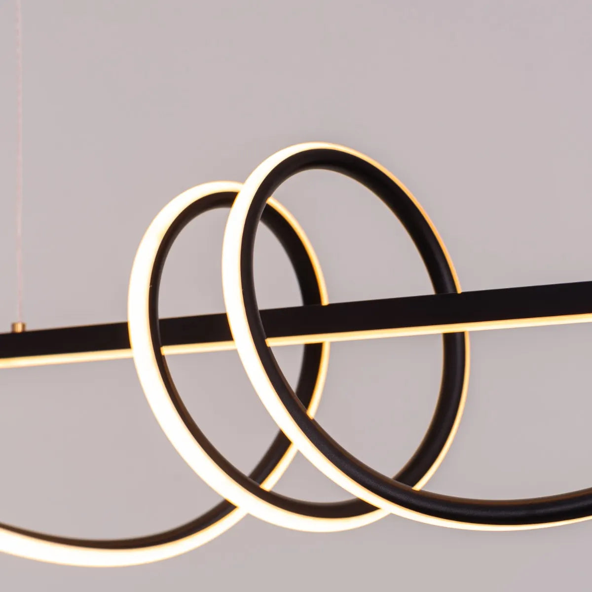 Up In The Air Chandelier suspended in a modern living room, its black elements contrasting dramatically with warm white light.