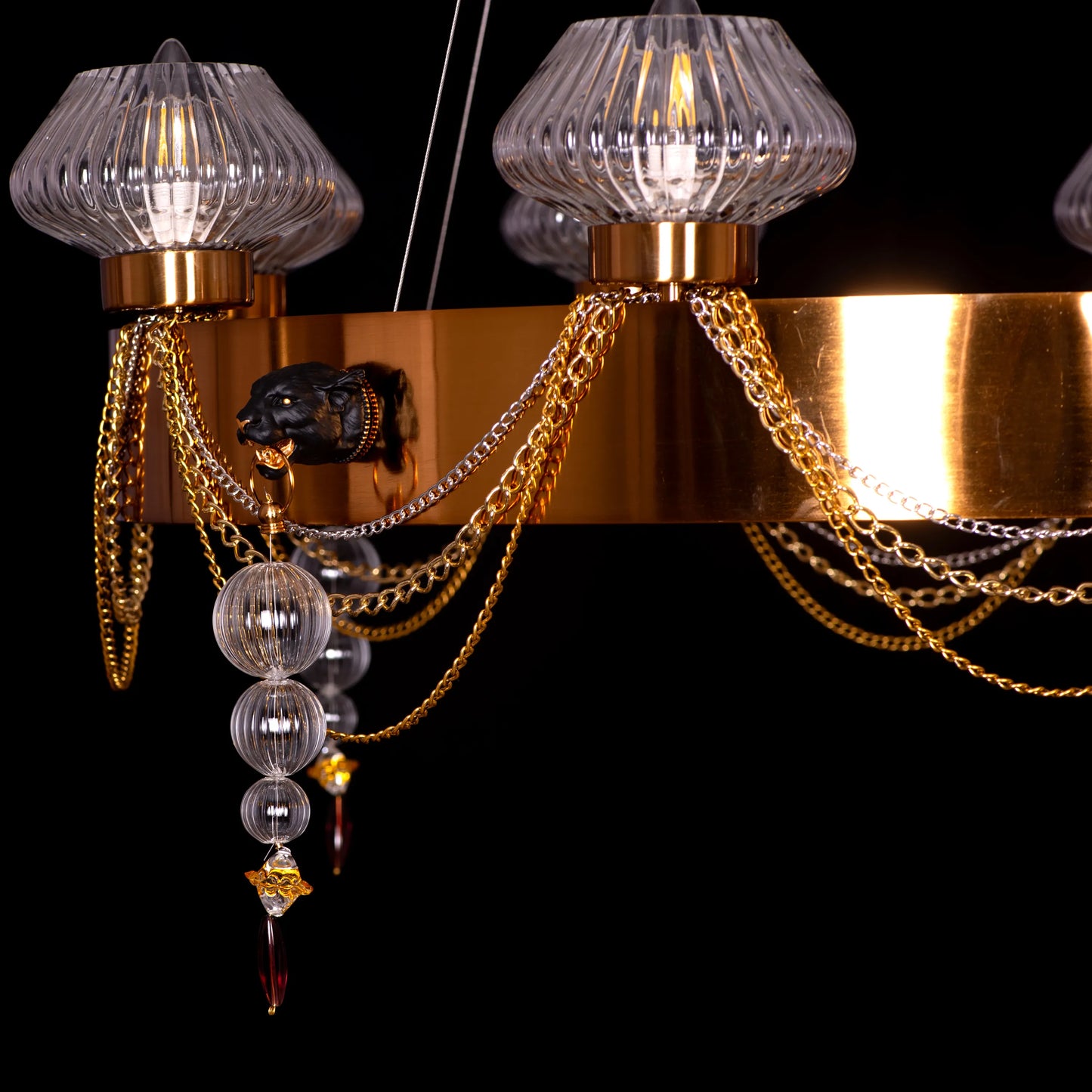 Large "Heart Is Beating" gold and clear glass chandelier, illuminated and suspended in a spacious, elegant room.