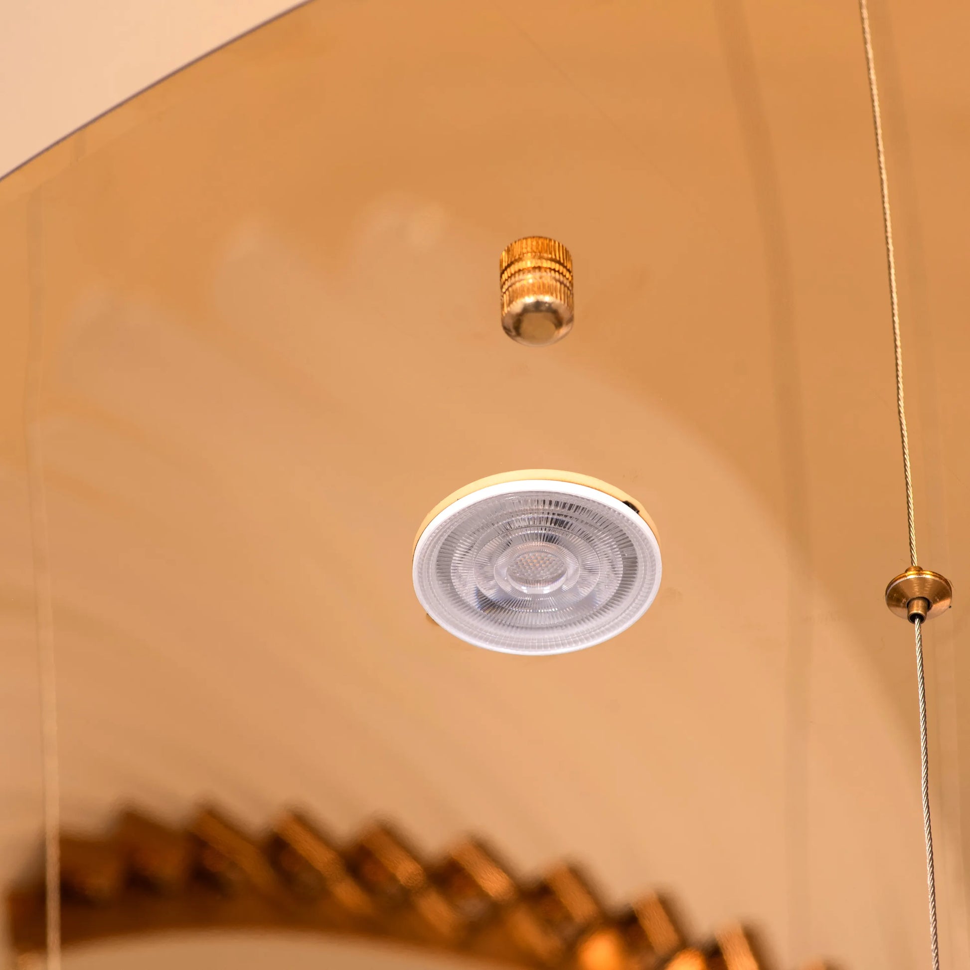 Large gold and white Chefs Kiss chandelier with frosted glass, hanging in a spacious living room