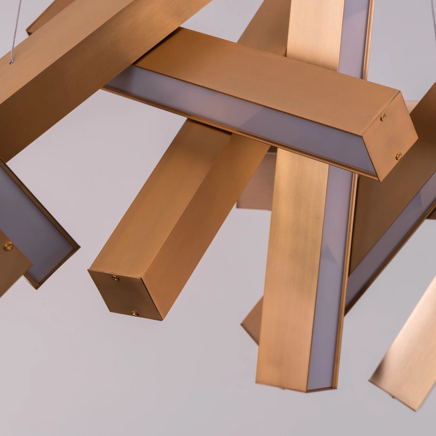 Large "Glow Miles" gold chandelier with multiple LED light sources, dramatically illuminated in a spacious, modern room.