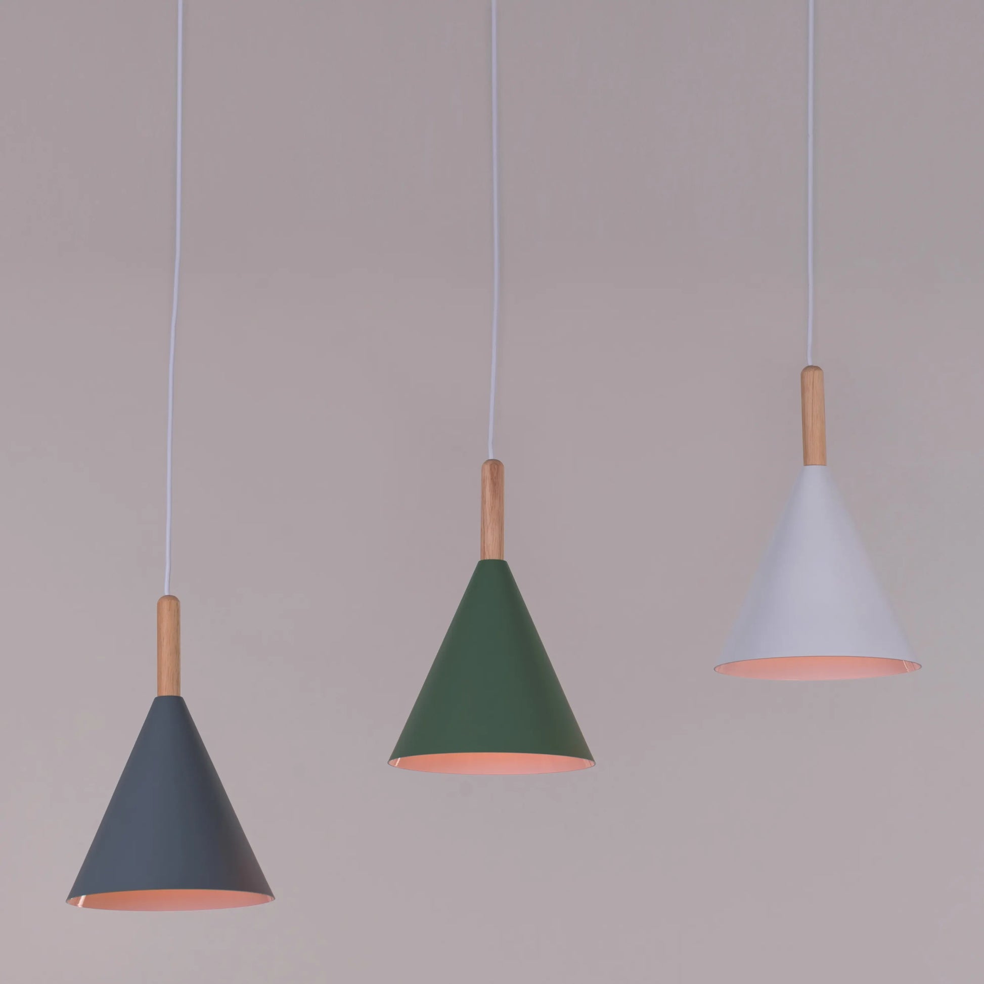 A vibrant pendant light named 'Bonus Points,' featuring three hanging heads in a playful combination of blue, green, and white. Each pendant has a smooth, minimalist design with sleek curves, creating a modern and cheerful aesthetic. The multi-colored arrangement adds a pop of color and a fun, dynamic vibe to any room.