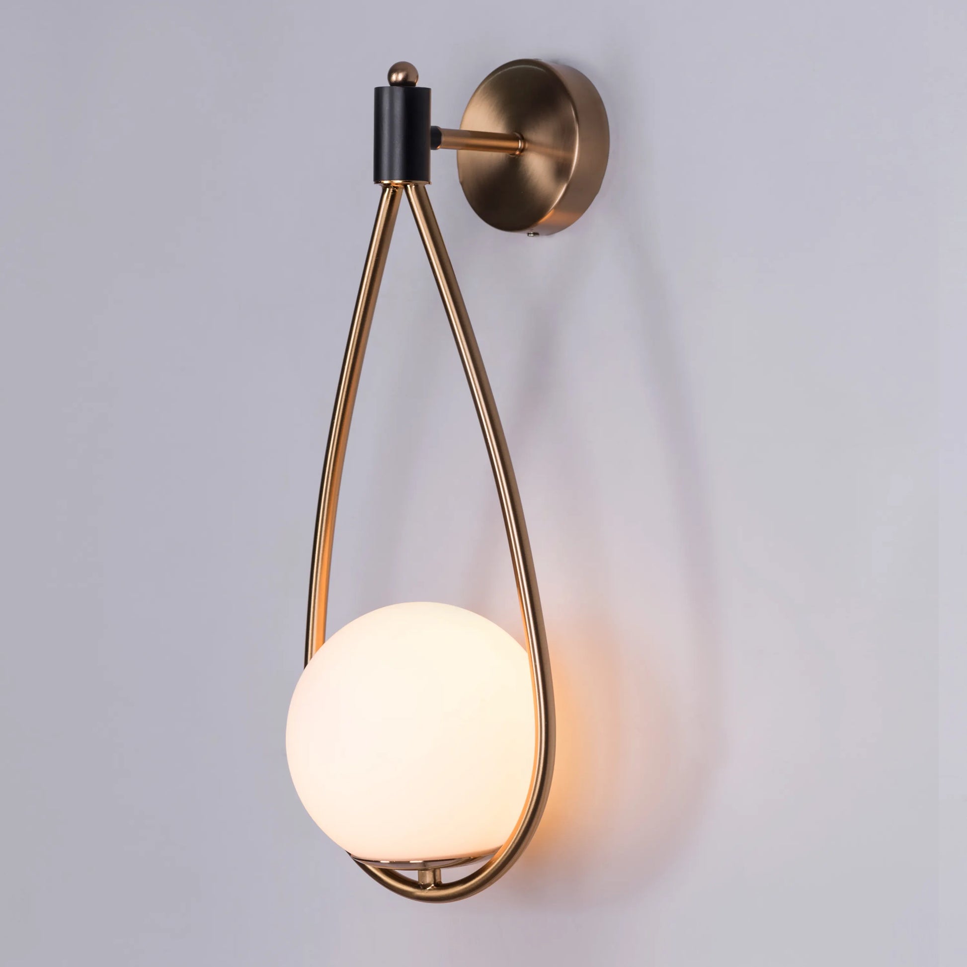 Sleek glass and metal wall light adding warmth to a minimalist living room.