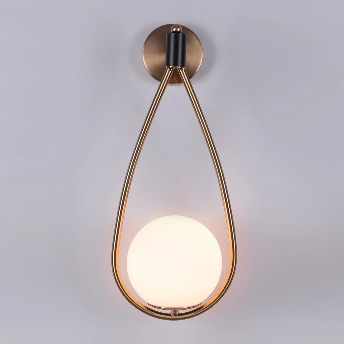 Sleek glass and metal wall light adding warmth to a minimalist living room.