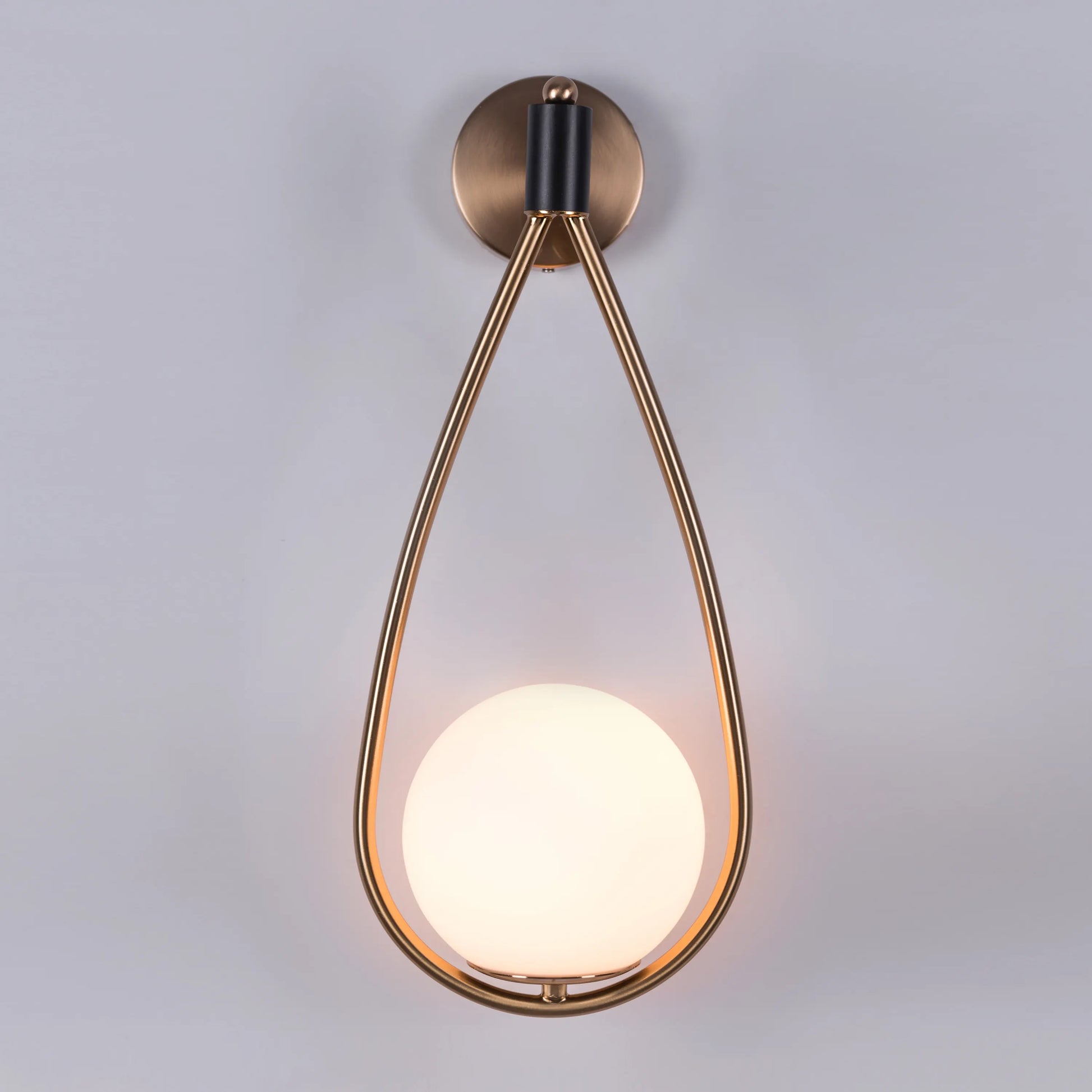 Sleek glass and metal wall light adding warmth to a minimalist living room.