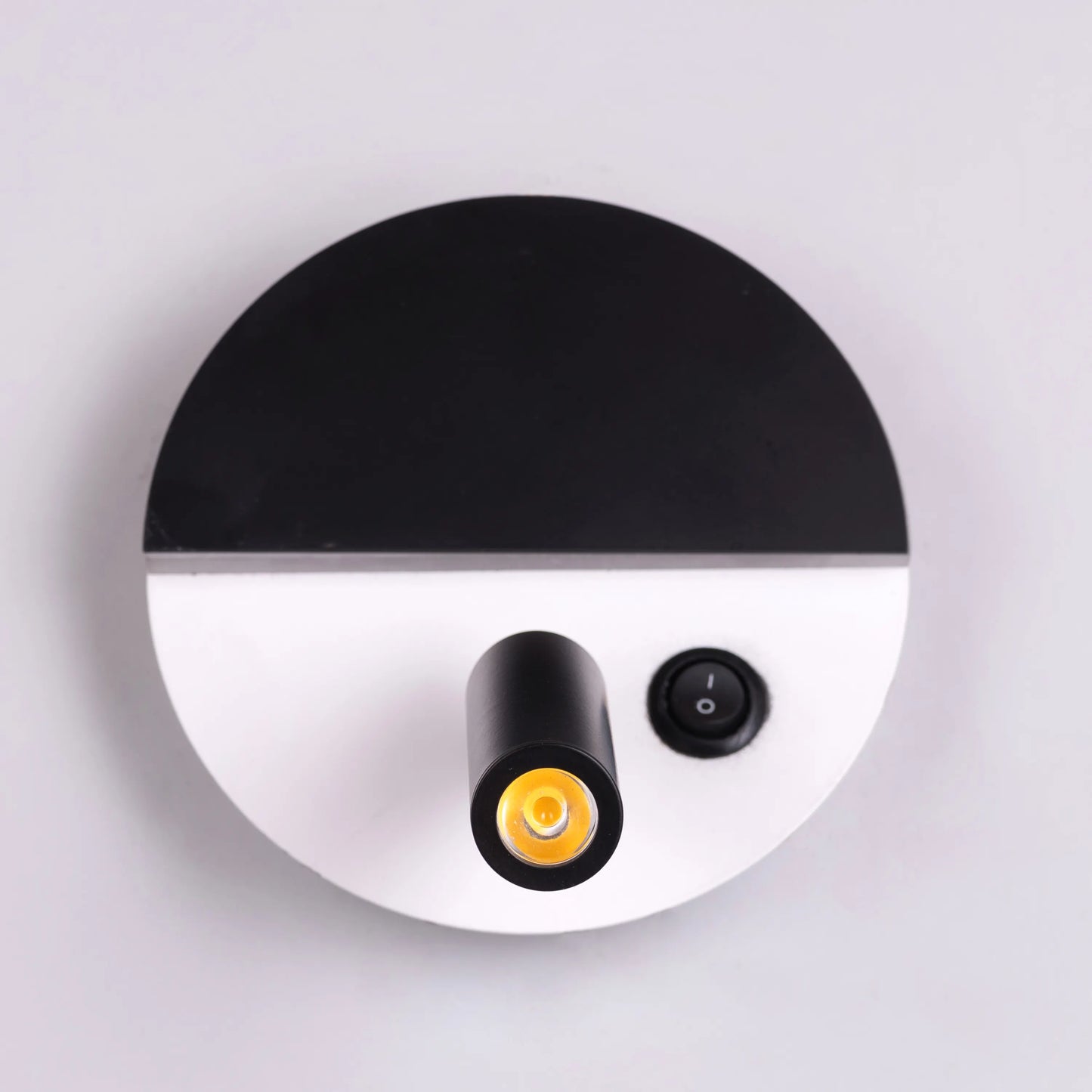 Elegant Elated Wall Light featuring a geometric layered design in brushed metal finish, projecting warm ambient light through crystal-clear glass elements against a neutral wall