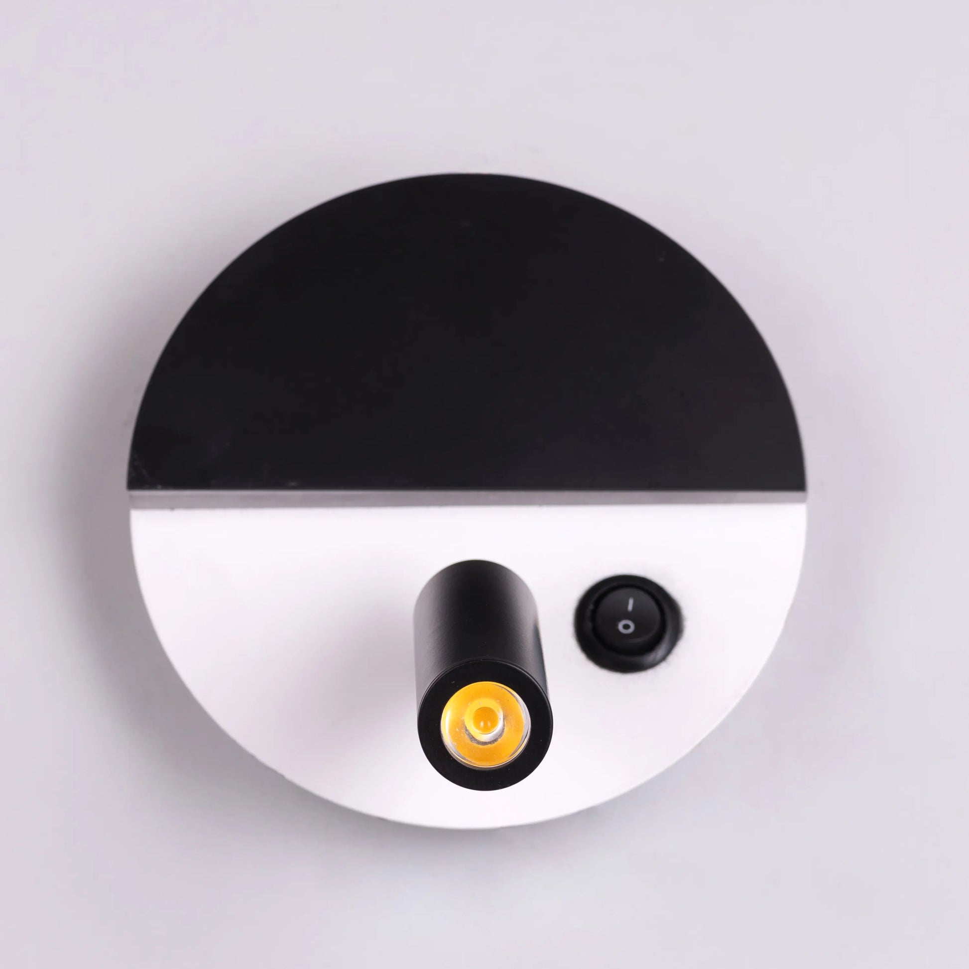 Elegant Elated Wall Light featuring a geometric layered design in brushed metal finish, projecting warm ambient light through crystal-clear glass elements against a neutral wall