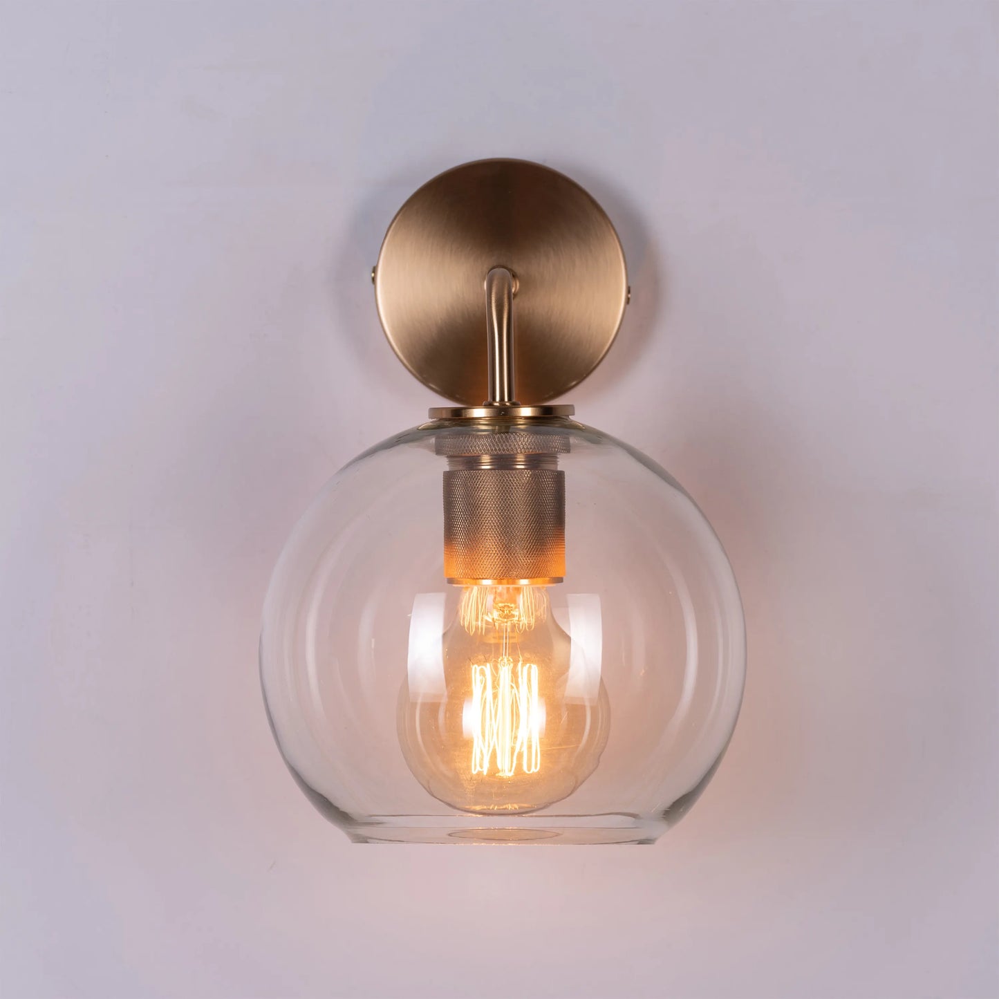 Endgame Clear Glass Wall Light - Minimalist and refined wall lighting fixture featuring a clear glass cylinder that houses the integrated LED light source, accentuated by a sleek metal housing.