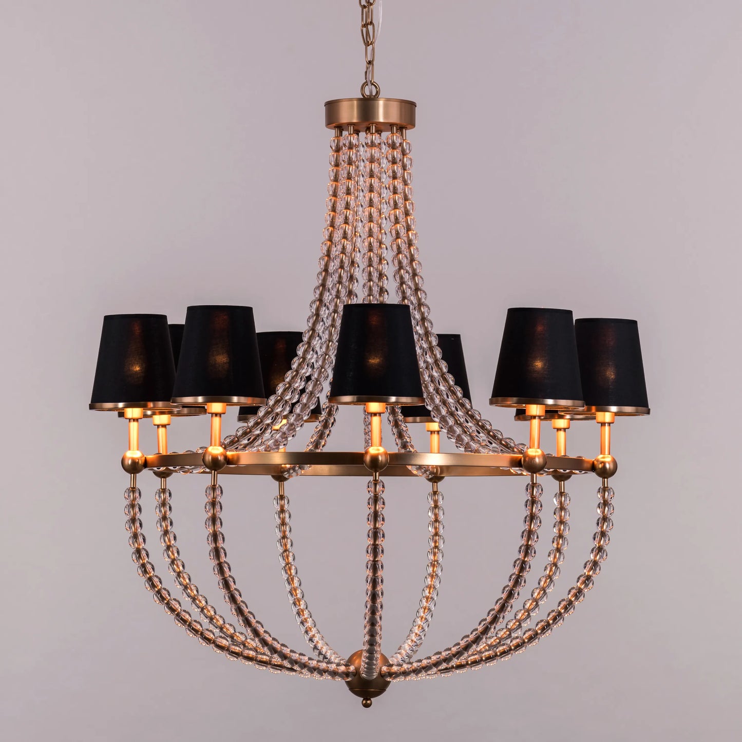 King's Gambit large gold crystal chandelier illuminating a grand entryway