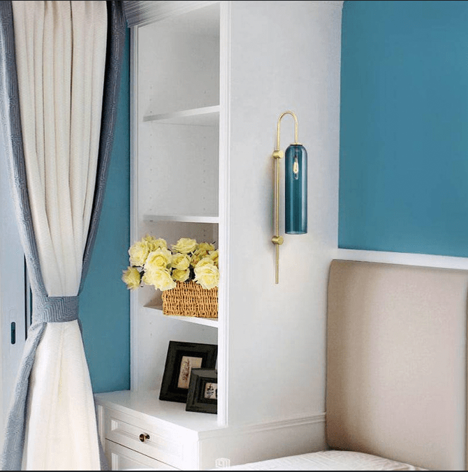 Gold-toned metal wall fixture, flickering flames, echoes of the past.