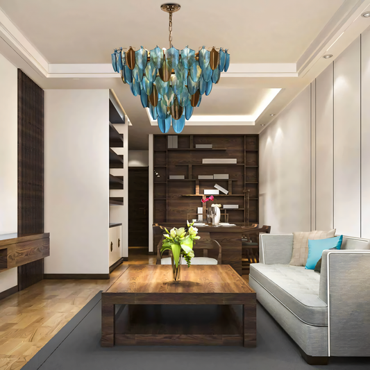 A modern glass leaf chandelier with a chrome frame hangs from a beach villa ceiling. The chandelier casts a soft, diffused glow on the space.