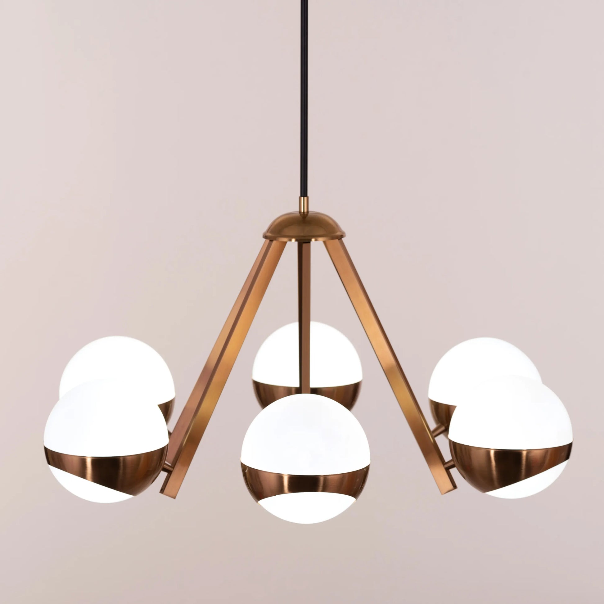 Prime Time Chandelier suspended in an elegant living room, its concentric gold rings casting a warm, inviting glow that draws the eye upward.