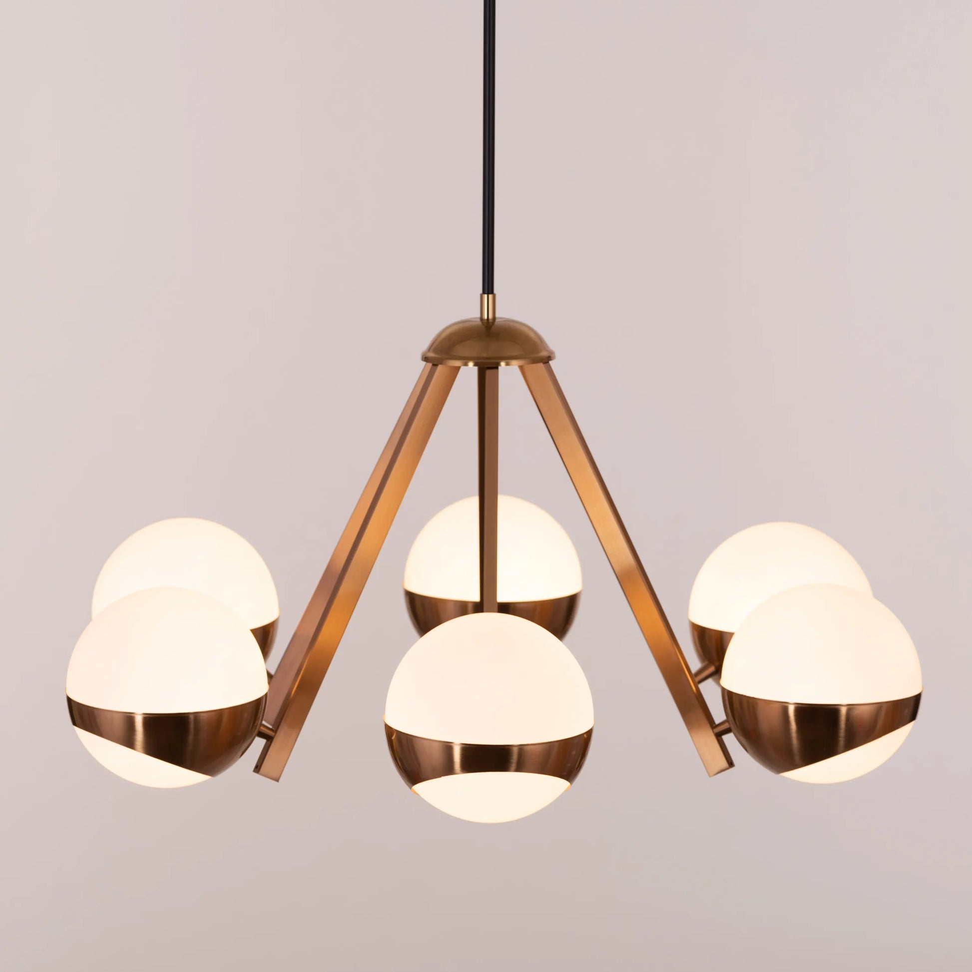 Prime Time Chandelier suspended in an elegant living room, its concentric gold rings casting a warm, inviting glow that draws the eye upward.