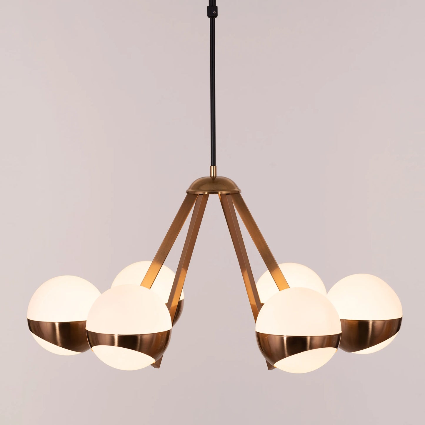 Prime Time Chandelier suspended in an elegant living room, its concentric gold rings casting a warm, inviting glow that draws the eye upward.