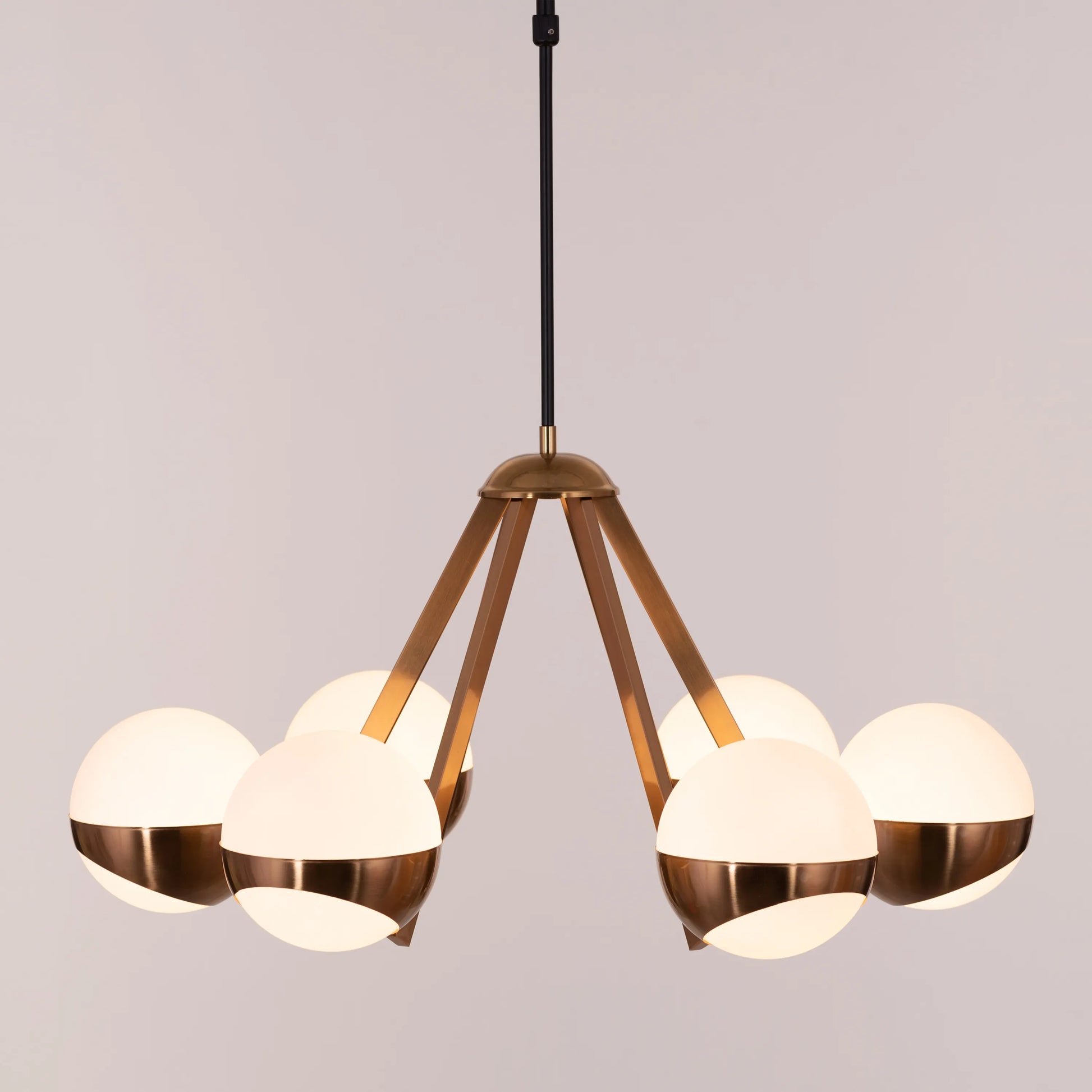 Prime Time Chandelier suspended in an elegant living room, its concentric gold rings casting a warm, inviting glow that draws the eye upward.