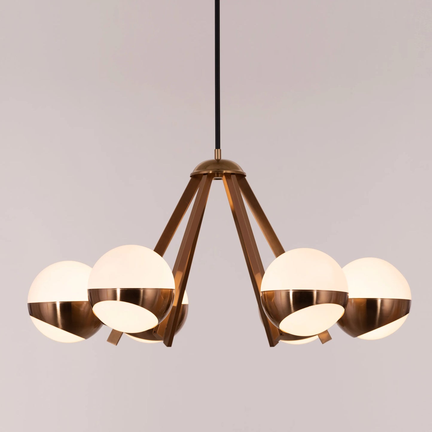 Prime Time Chandelier suspended in an elegant living room, its concentric gold rings casting a warm, inviting glow that draws the eye upward.