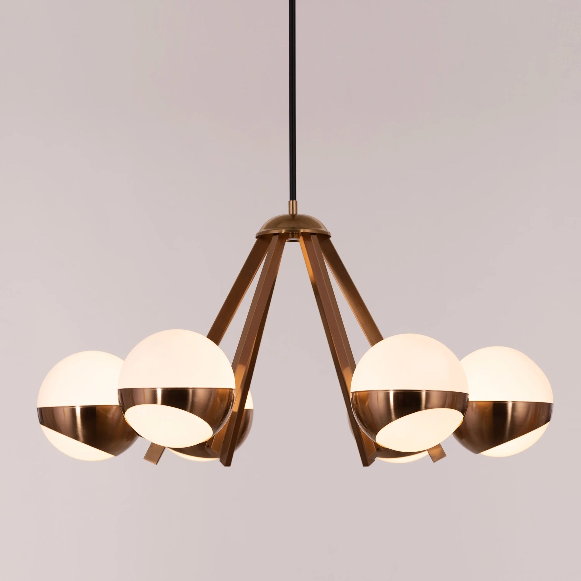 Prime Time Chandelier suspended in an elegant living room, its concentric gold rings casting a warm, inviting glow that draws the eye upward.