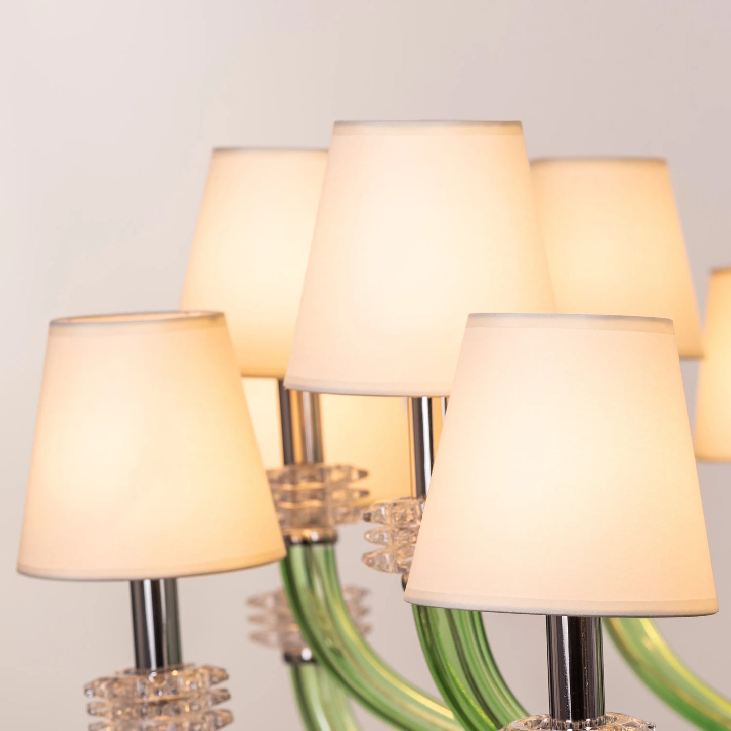 Large green and white glass chandelier with cloud-like forms and warm lighting