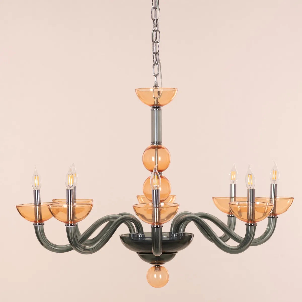 Large "Steps Of Rome" chandelier with tiered green and amber glass elements, dramatically illuminated in a spacious, elegant room.