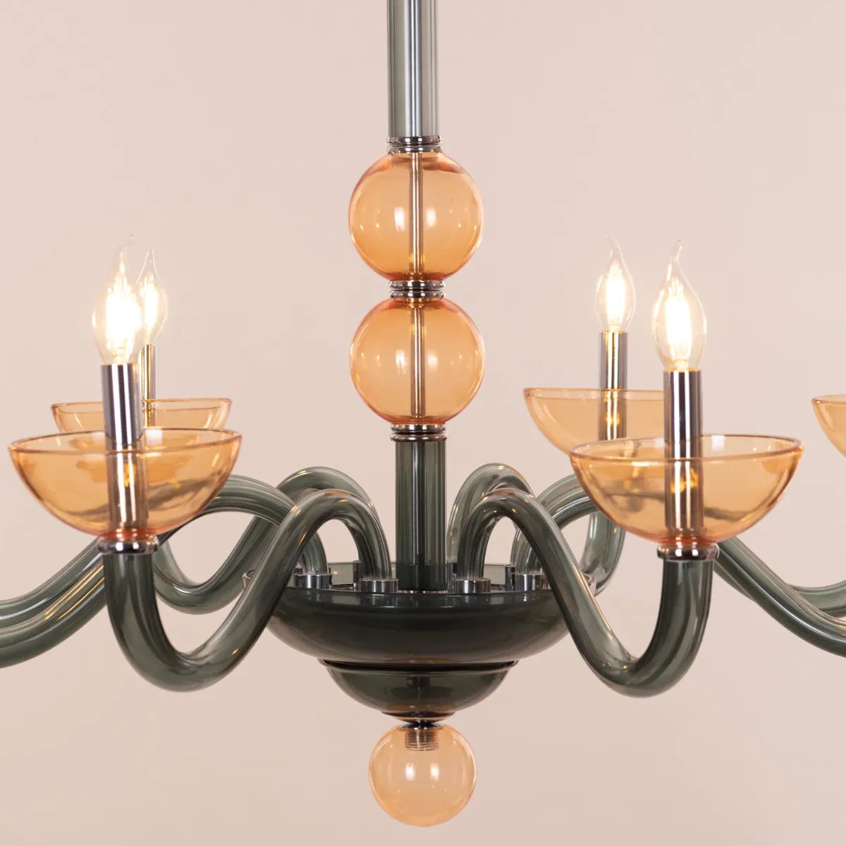 Large "Steps Of Rome" chandelier with tiered green and amber glass elements, dramatically illuminated in a spacious, elegant room.