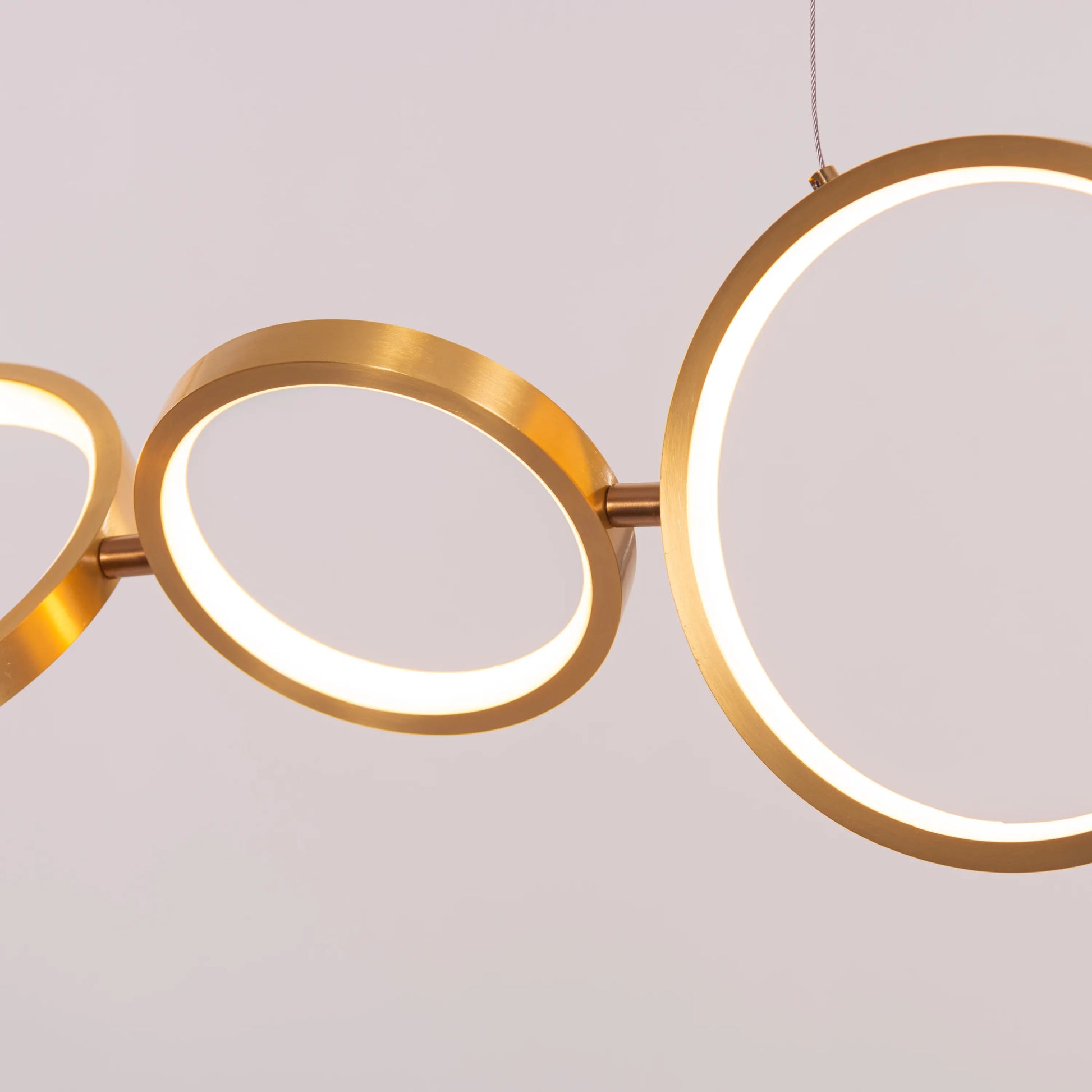 Large gold How We Play chandelier with playful design elements illuminating a luxurious living room