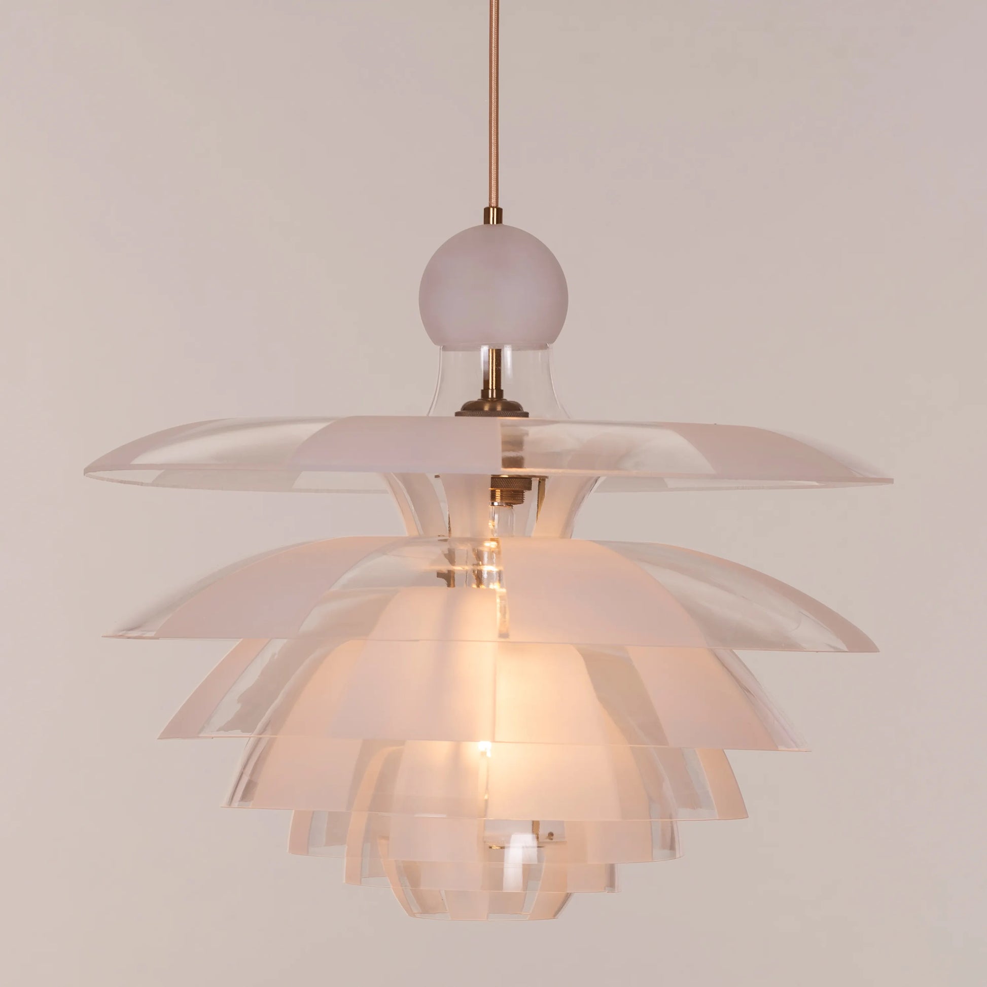 A striking pendant light named 'Find Your Truth,' featuring a unique geometric design that combines metal and glass elements. The fixture has a polished finish that reflects light beautifully, creating a captivating visual effect. Its modern aesthetic and artistic shape serve as a statement piece, adding elegance and intrigue to any room.