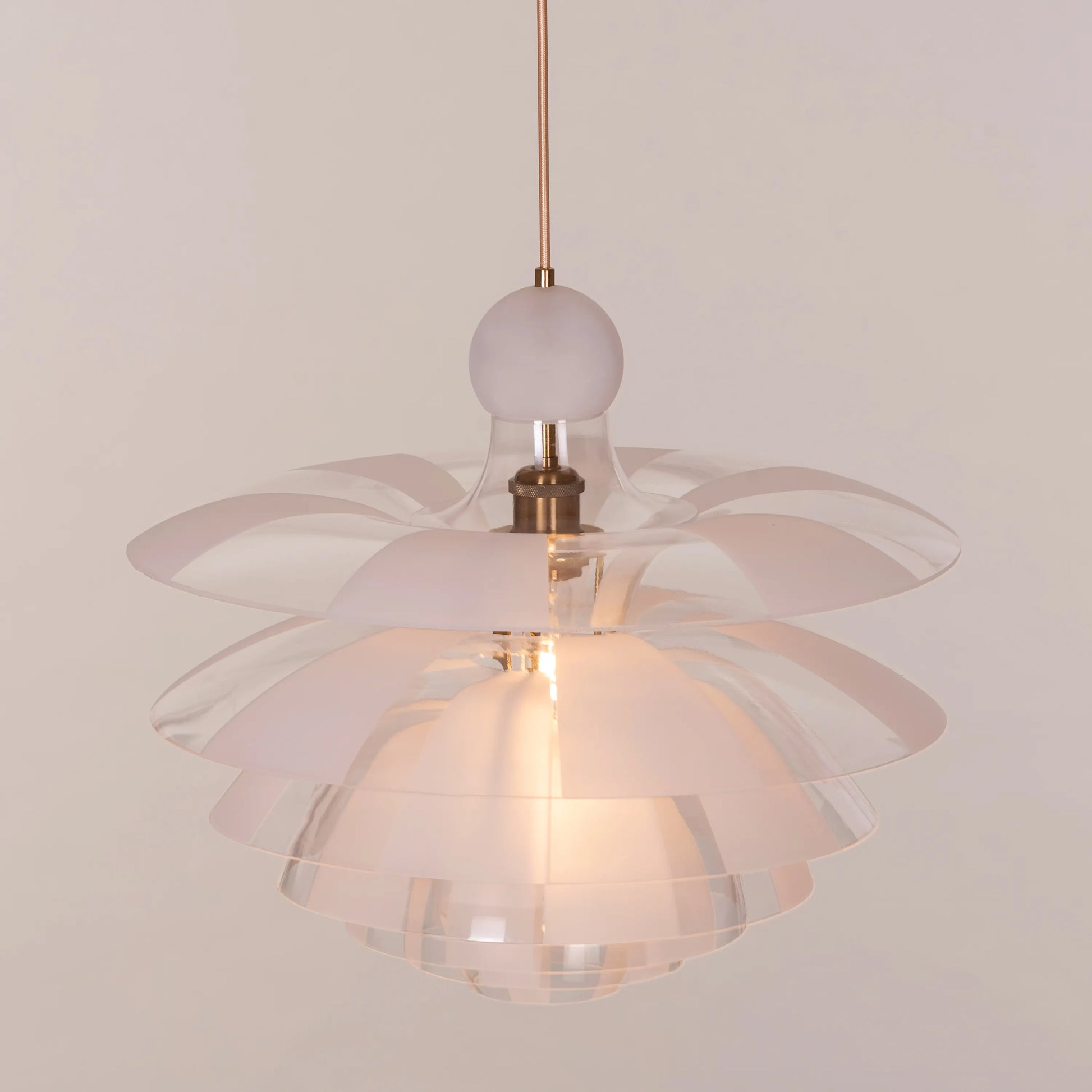 A striking pendant light named 'Find Your Truth,' featuring a unique geometric design that combines metal and glass elements. The fixture has a polished finish that reflects light beautifully, creating a captivating visual effect. Its modern aesthetic and artistic shape serve as a statement piece, adding elegance and intrigue to any room.