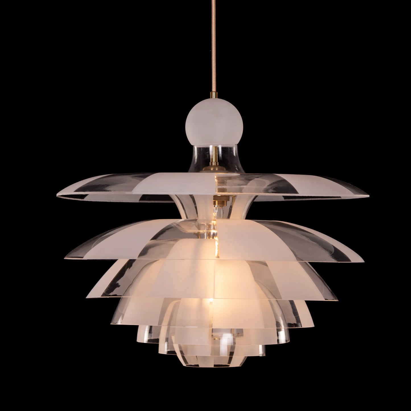 A striking pendant light named 'Find Your Truth,' featuring a unique geometric design that combines metal and glass elements. The fixture has a polished finish that reflects light beautifully, creating a captivating visual effect. Its modern aesthetic and artistic shape serve as a statement piece, adding elegance and intrigue to any room.