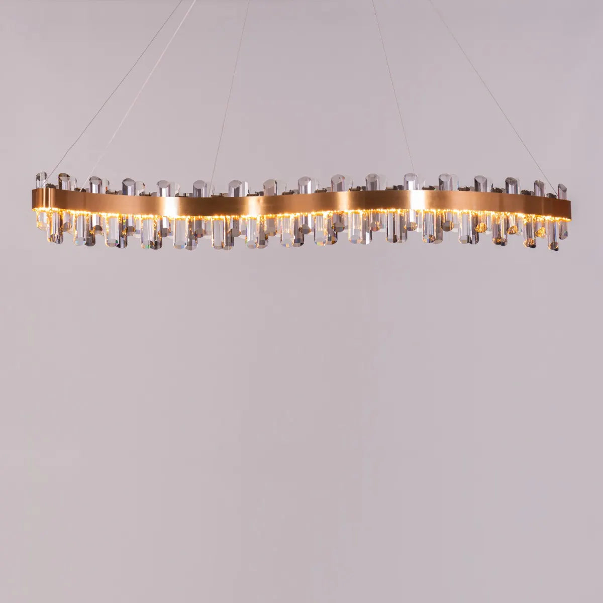 Start From Scratch long crystal chandelier illuminating a grand, open-concept living space