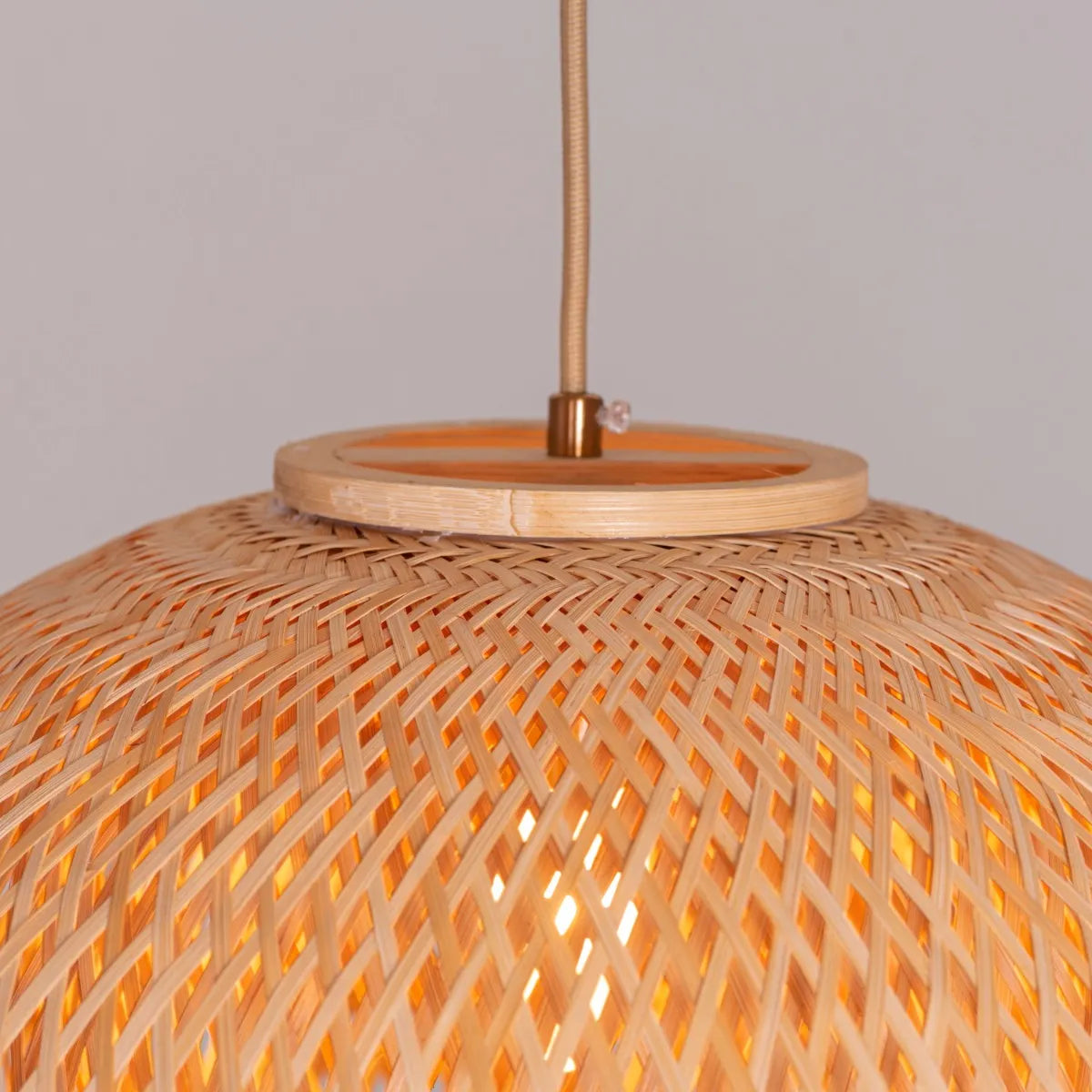 A unique rattan pendant light named 'Never The Same,' featuring a handcrafted, woven rattan shade with an organic, irregular shape. The natural fibers create a warm, inviting glow as light filters through the intricate patterns, offering a bohemian, rustic charm that adds texture and character to any space.