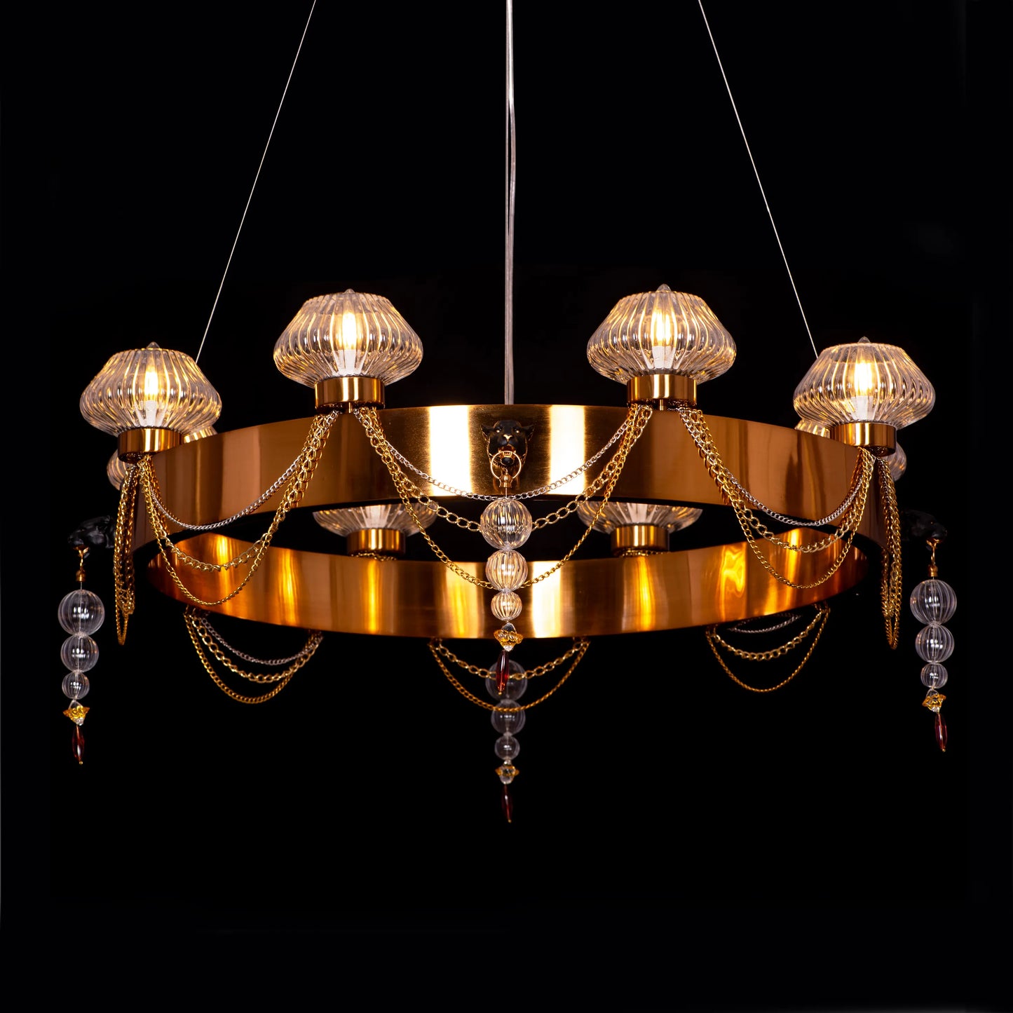 Large "Heart Is Beating" gold and clear glass chandelier, illuminated and suspended in a spacious, elegant room.