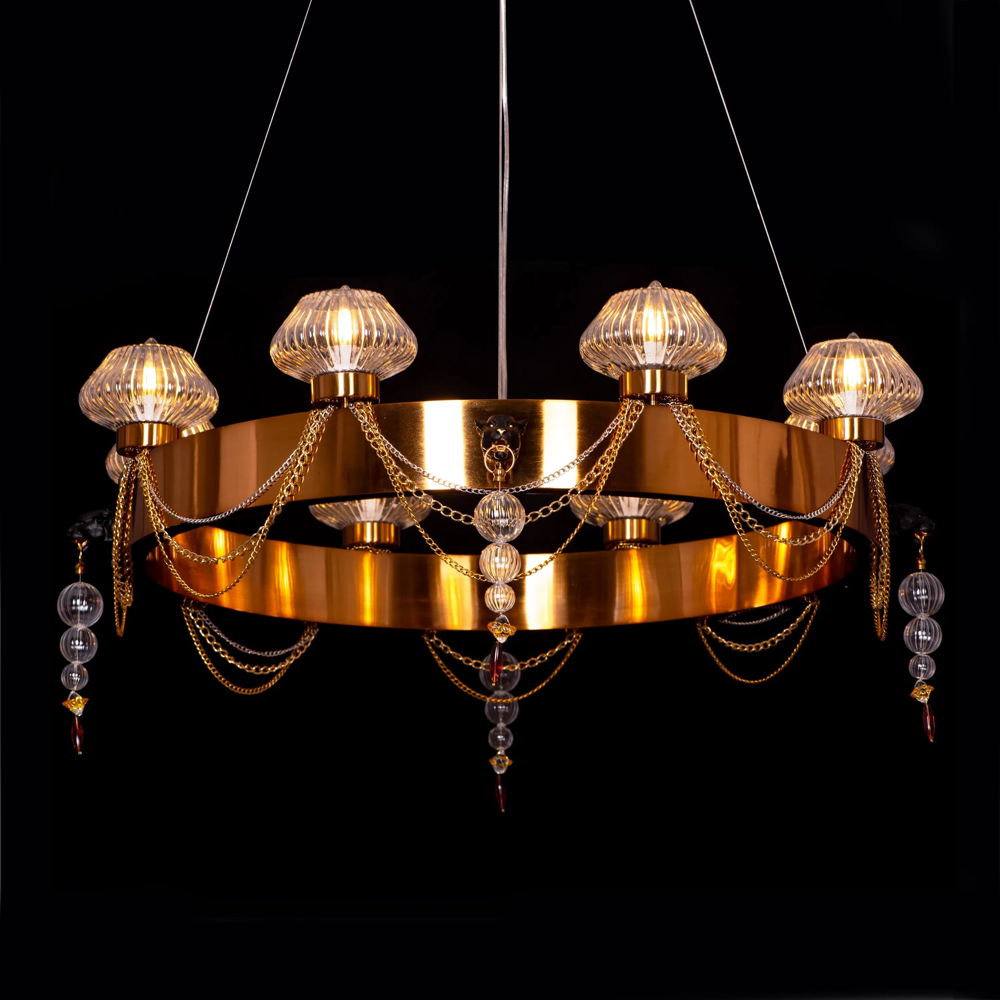 Large "Heart Is Beating" gold and clear glass chandelier, illuminated and suspended in a spacious, elegant room.