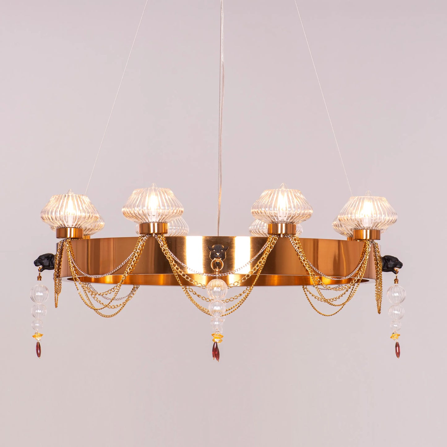 Large "Heart Is Beating" gold and clear glass chandelier, illuminated and suspended in a spacious, elegant room.