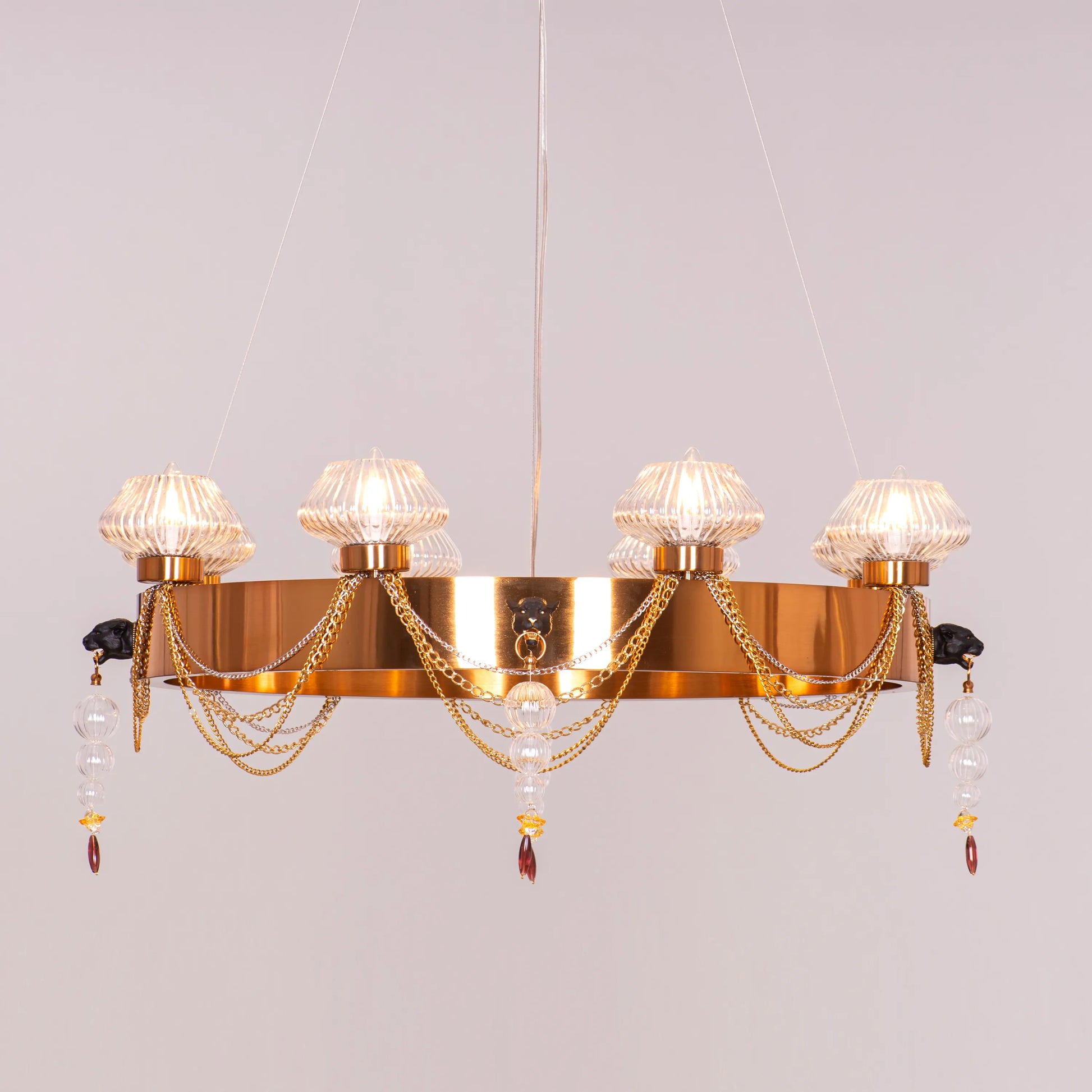 Large "Heart Is Beating" gold and clear glass chandelier, illuminated and suspended in a spacious, elegant room.