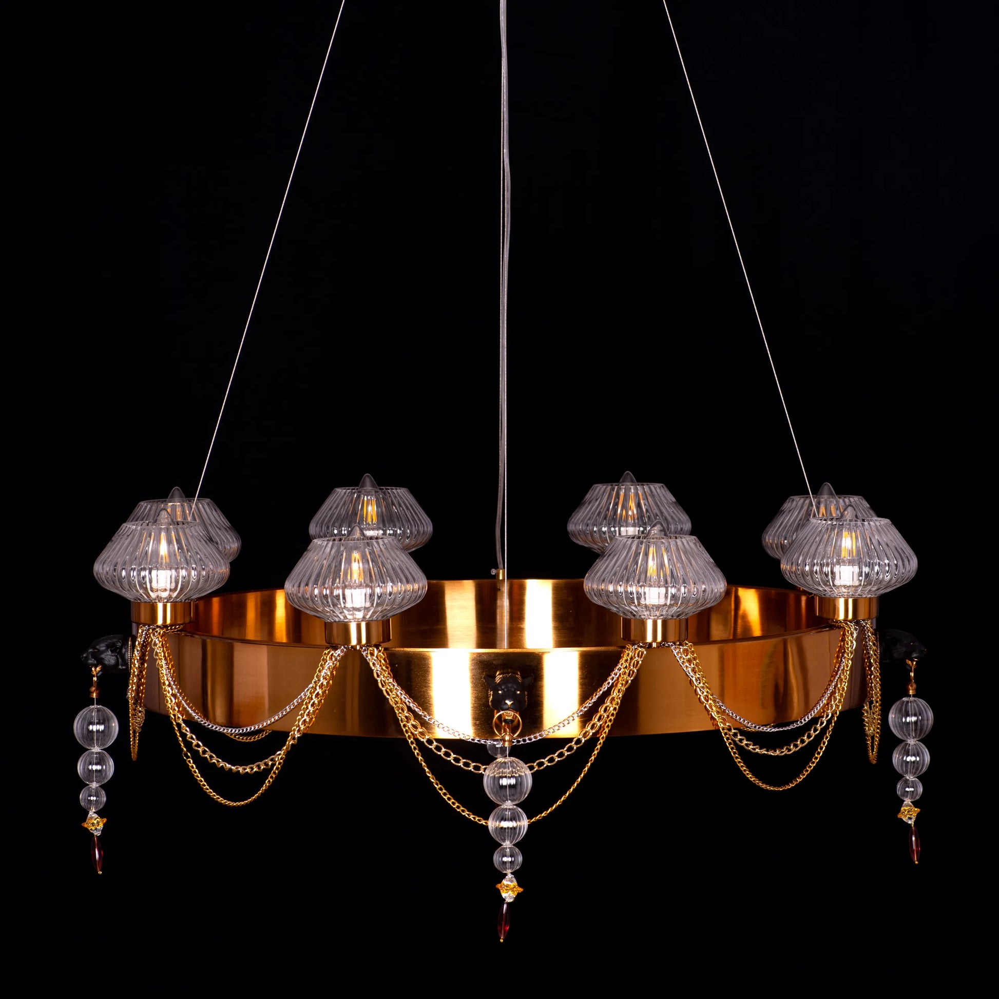 Large "Heart Is Beating" gold and clear glass chandelier, illuminated and suspended in a spacious, elegant room.