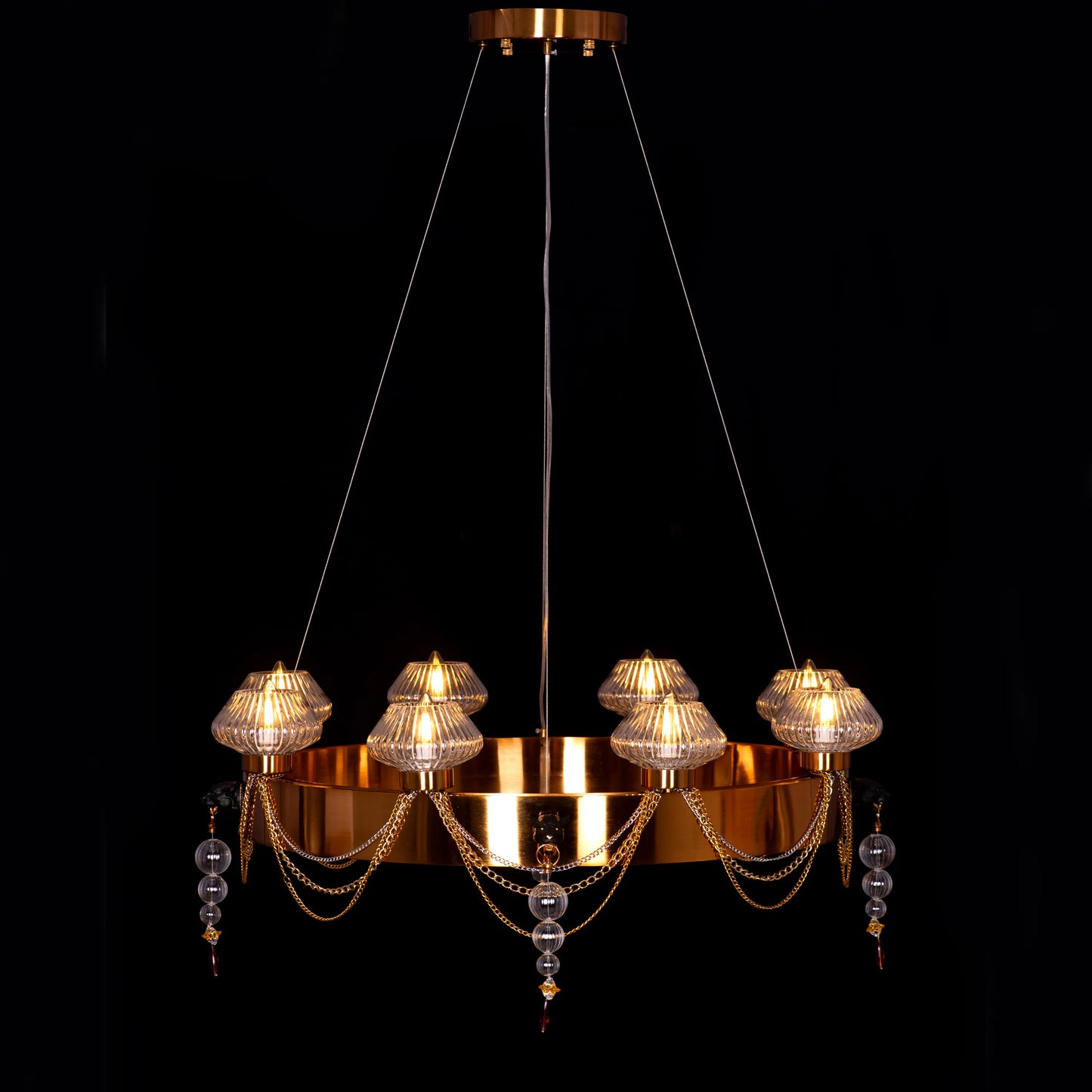 Large "Heart Is Beating" gold and clear glass chandelier, illuminated and suspended in a spacious, elegant room.