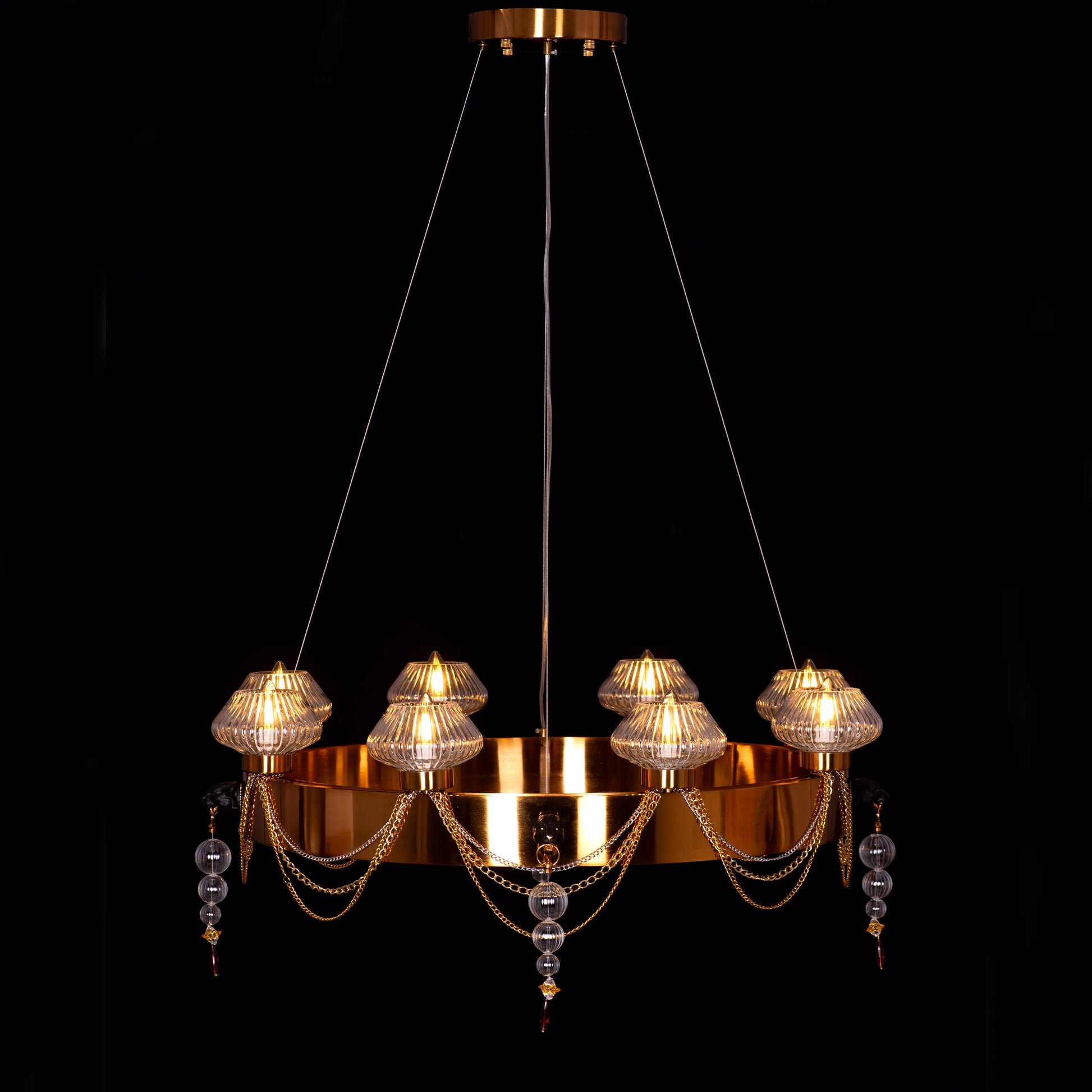 Large "Heart Is Beating" gold and clear glass chandelier, illuminated and suspended in a spacious, elegant room.