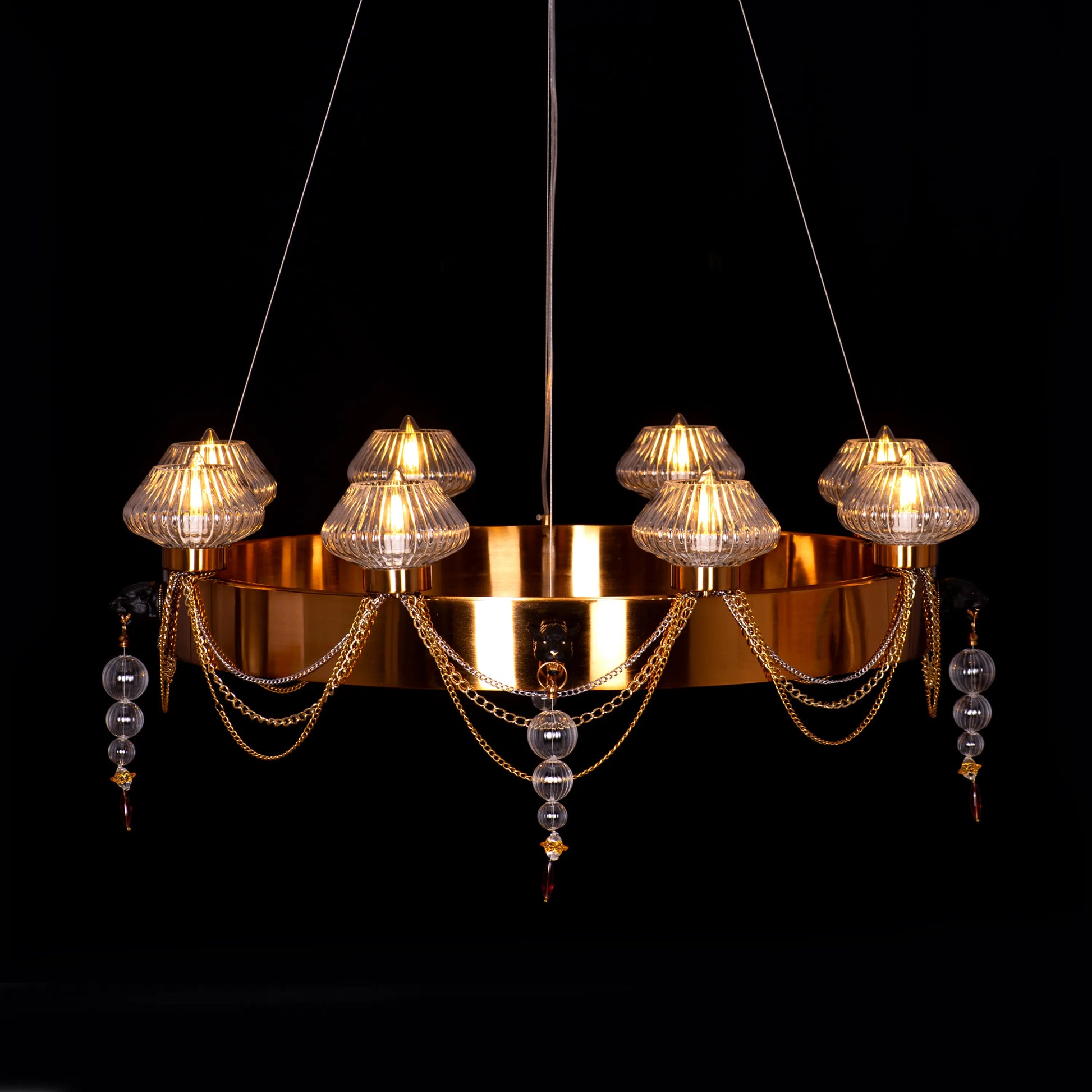 Large "Heart Is Beating" gold and clear glass chandelier, illuminated and suspended in a spacious, elegant room.