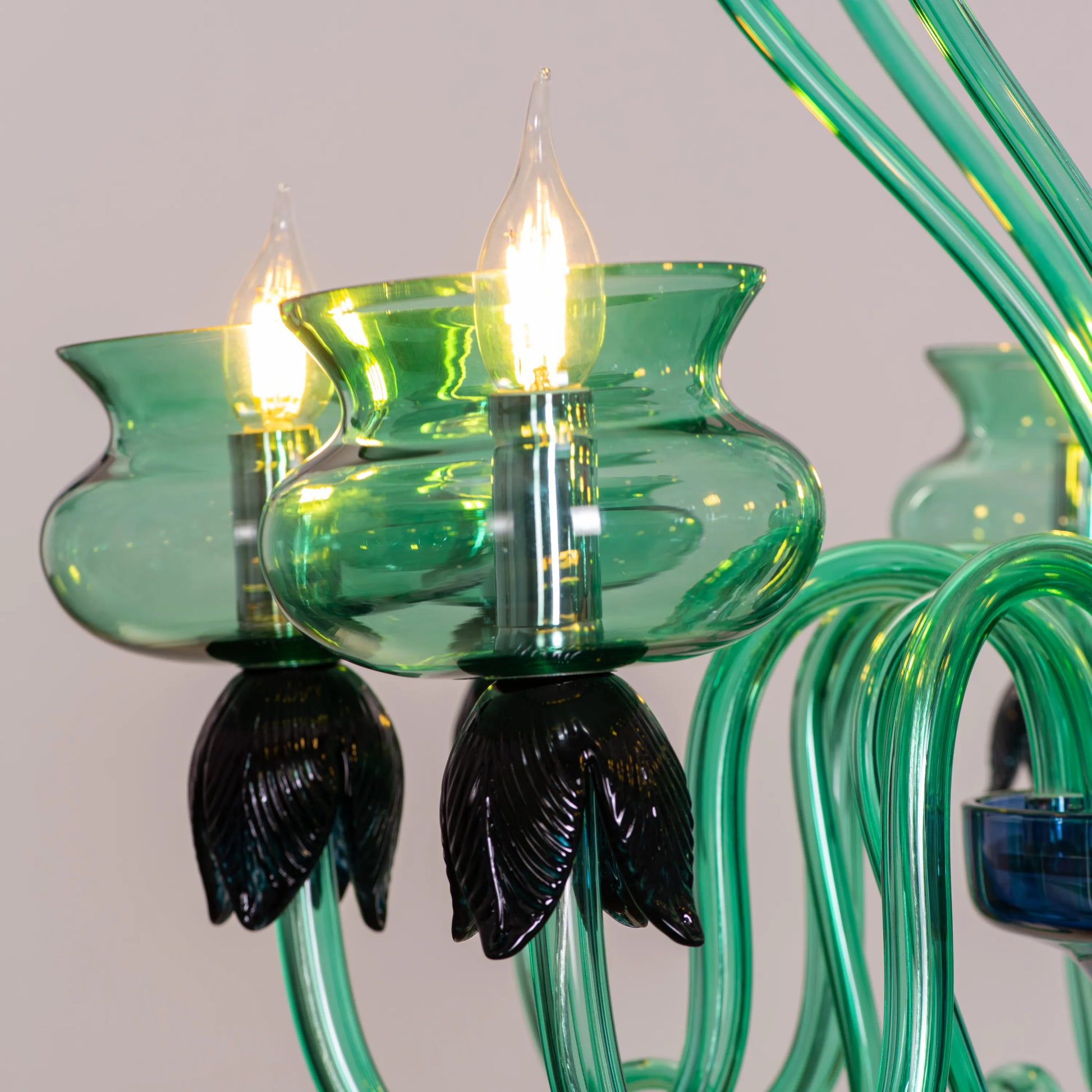 Kind To The Mind large green and blue clear glass chandelier illuminating a peaceful yoga studio