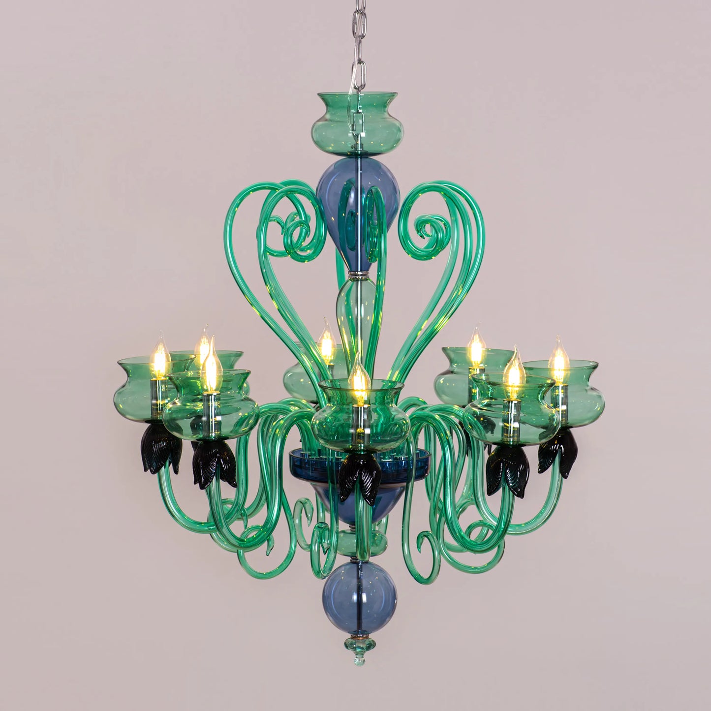 Kind To The Mind large green and blue clear glass chandelier illuminating a peaceful yoga studio